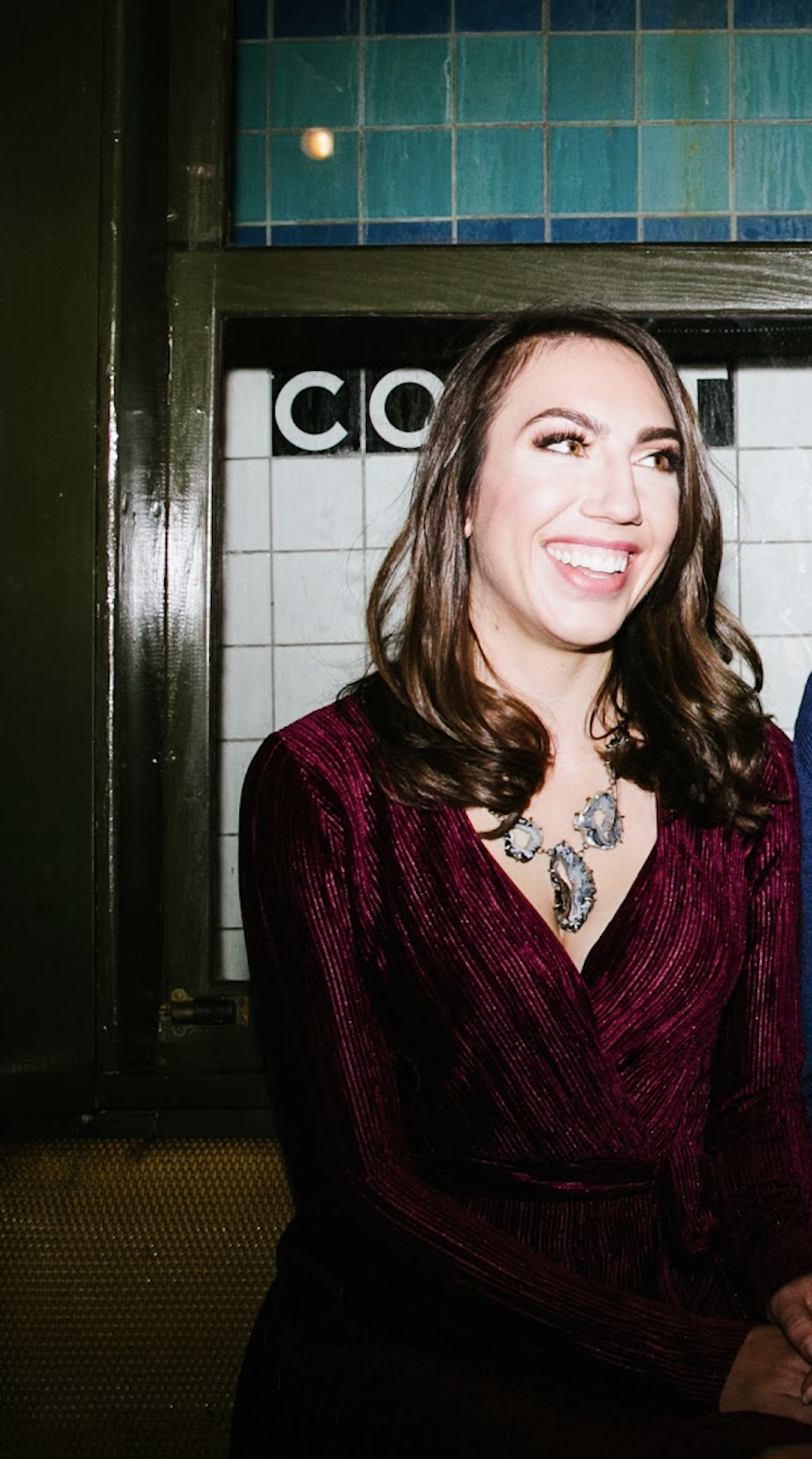 Cola, founder of The Avocado Method, in semi-formal style with glam makeup on the New York City subway, anti-aging style consulting that works anywhere