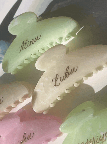 Colorful hair clips with engraved names, including Alina, Luba, and others.