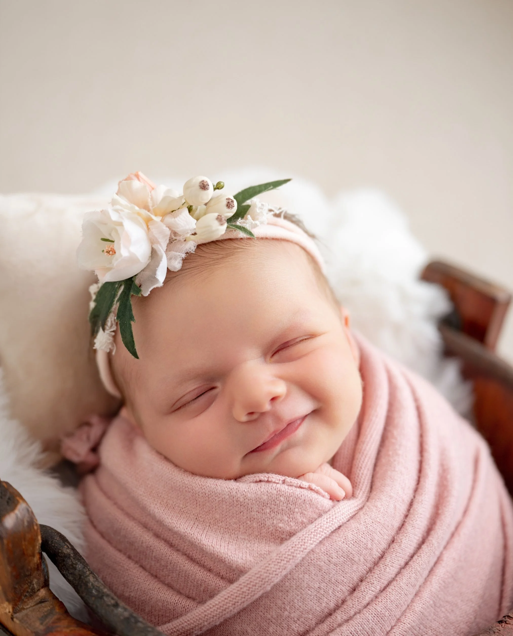 Newborn smiles are a rare little treat, and this sweet girl gave me SEVERAL! Those sleepy grins completely made the session.

We kept things soft and sweet with blush pink florals, and of course she had to make a Detroit Lions onesie appearance too. 