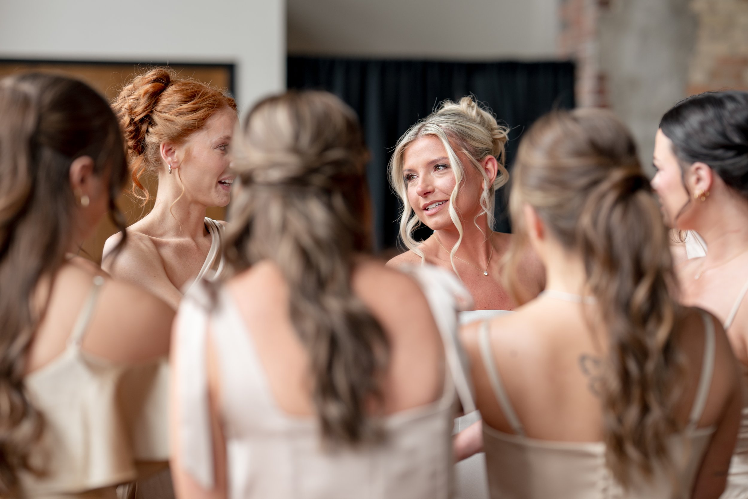 Candid of bride talking to bridesmaids. 
