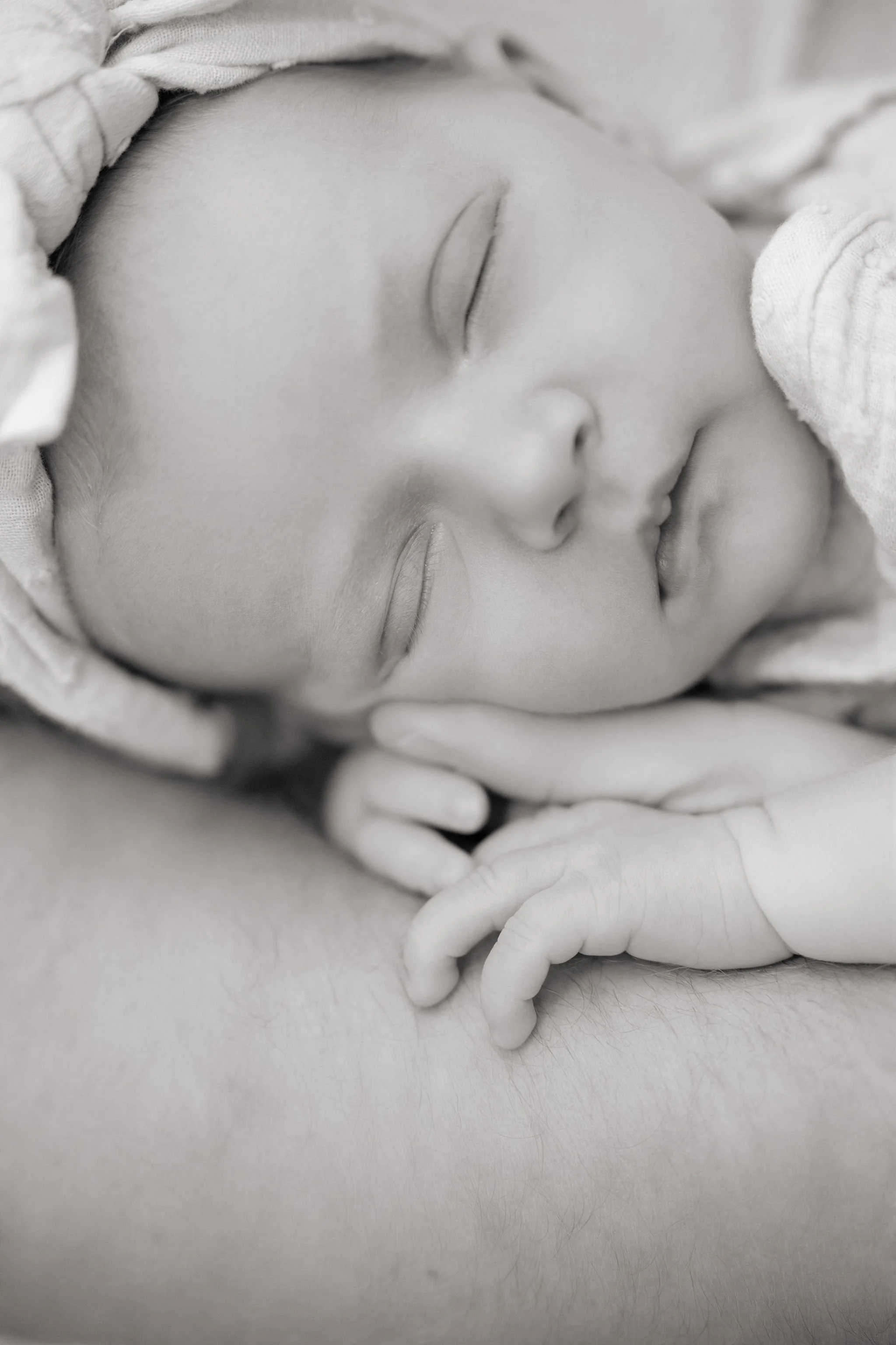 Baby laying on a parents arm