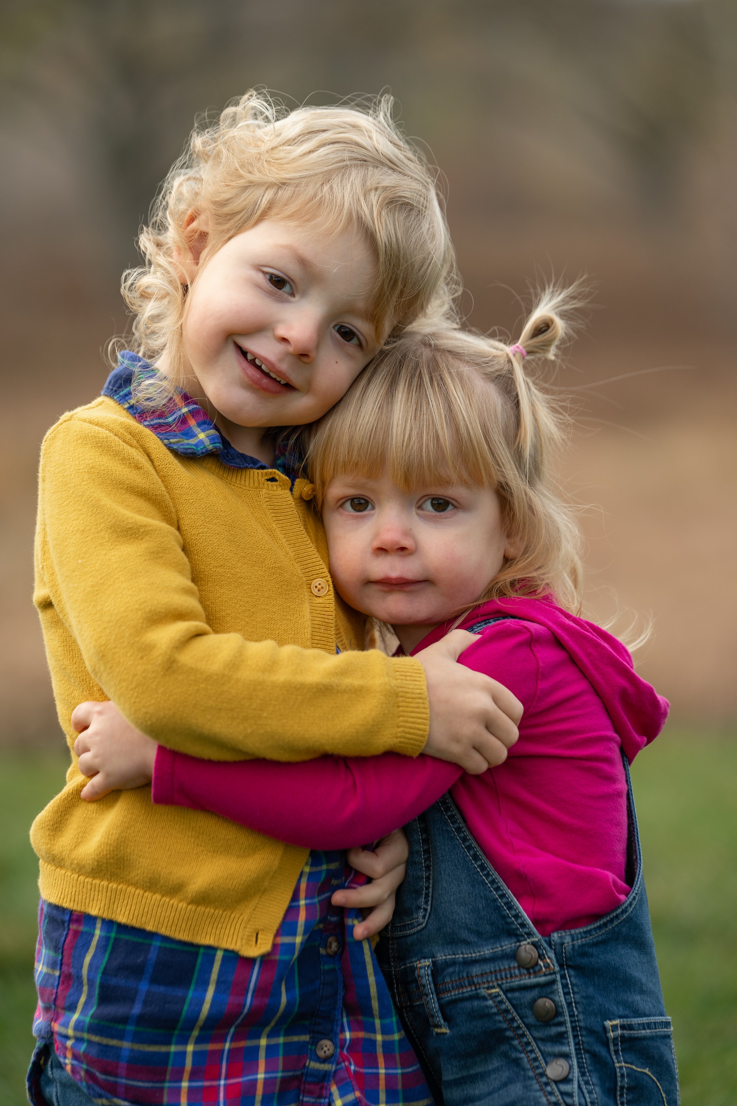 Kids wearing sweaters, and hugging during a Holland Michigan family photoshoot.