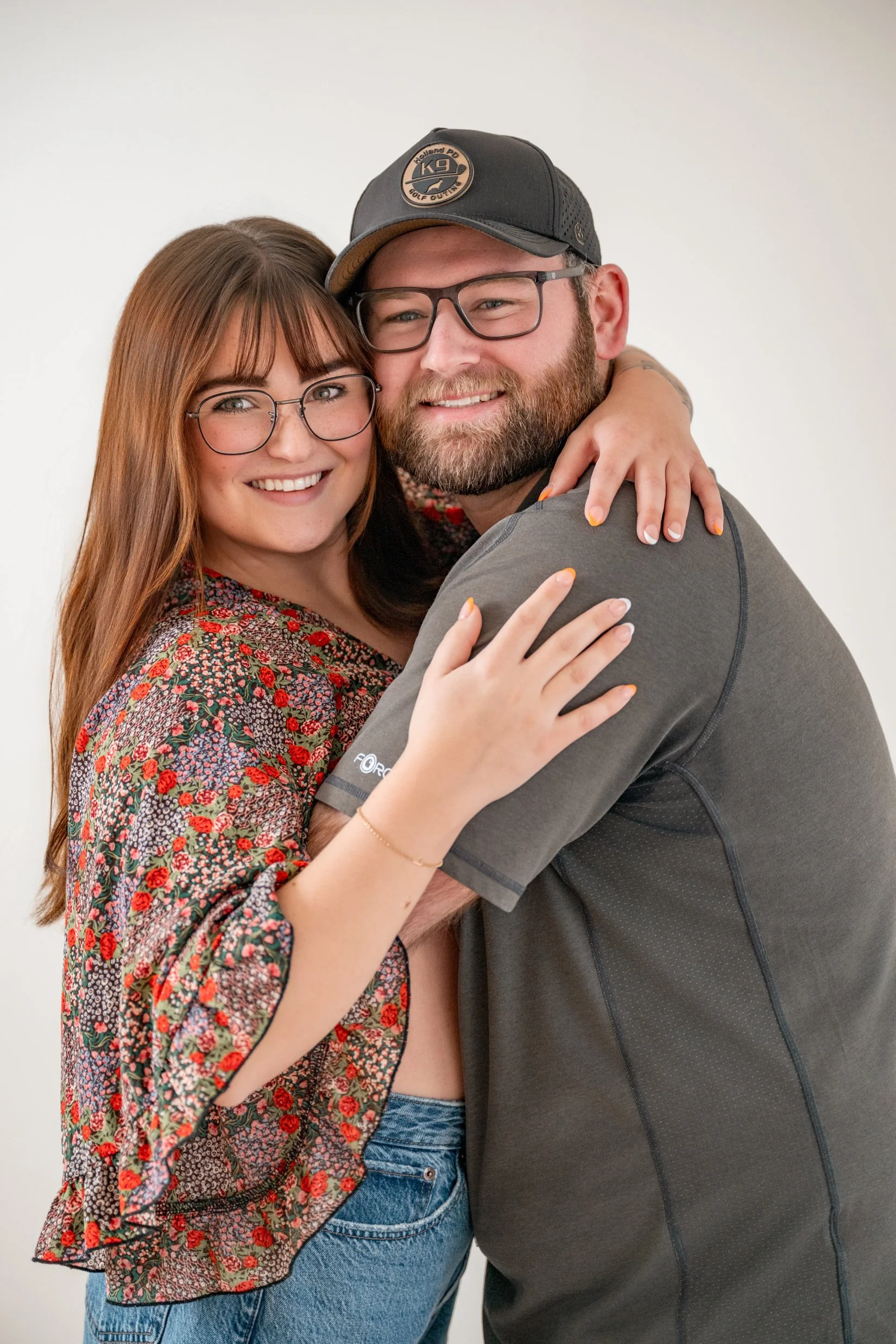 Couple posed with their faces next to each other with a white background Michigan Couples Photographer