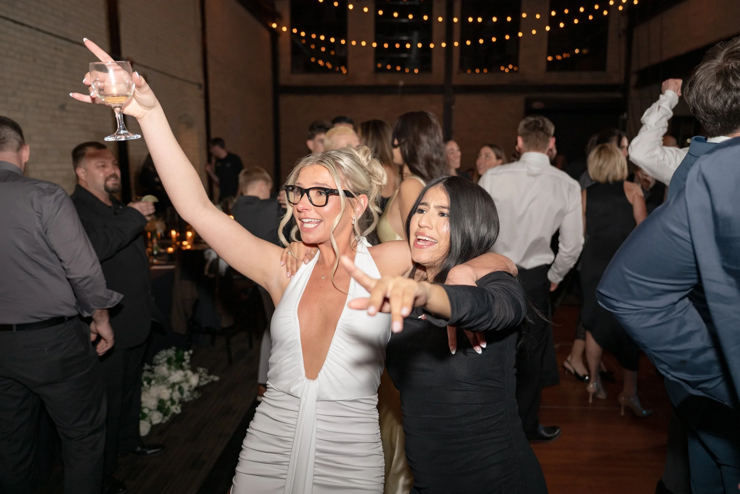 Bride celebrating with friends on the dance floor.