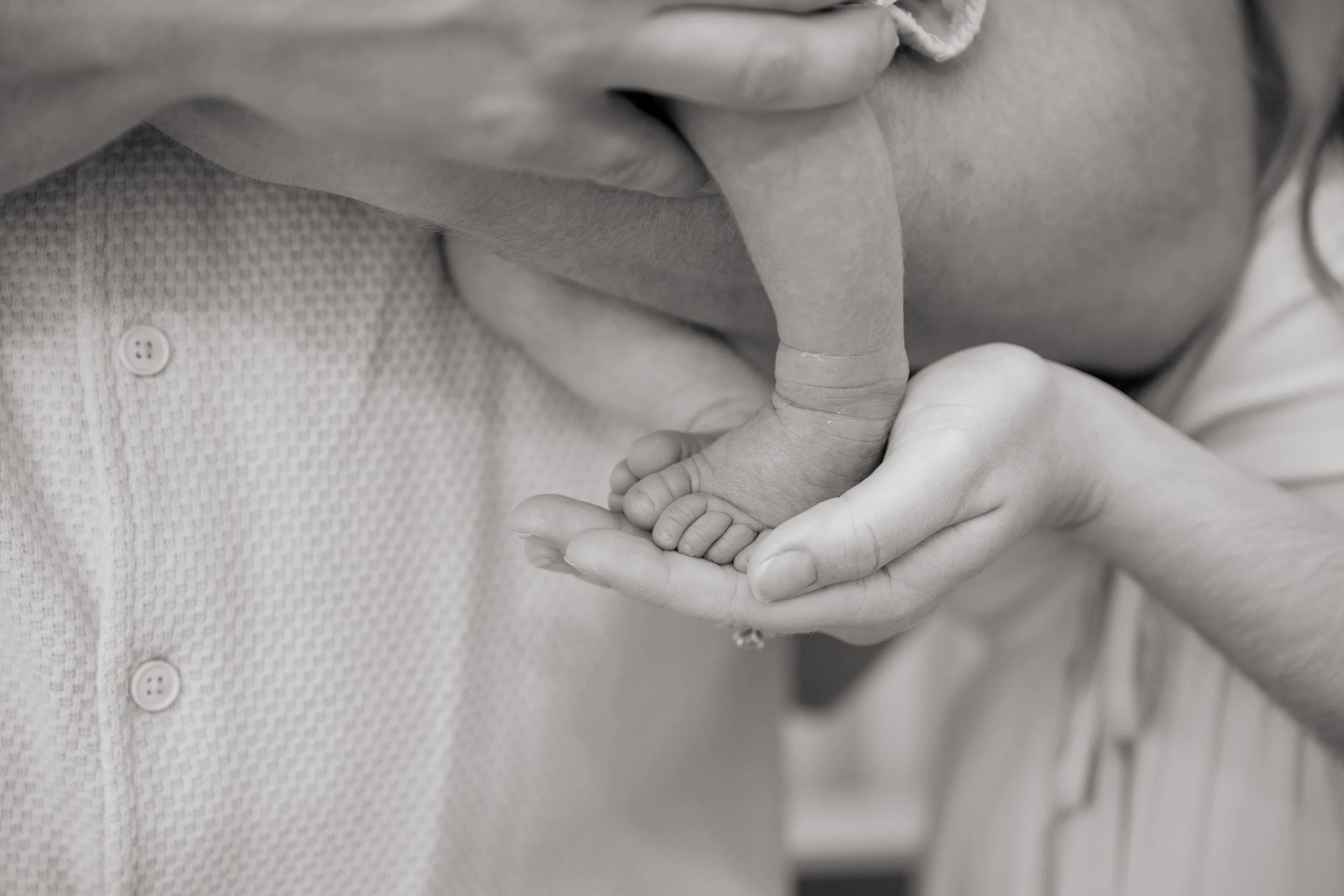 a hand holding on a baby's foot