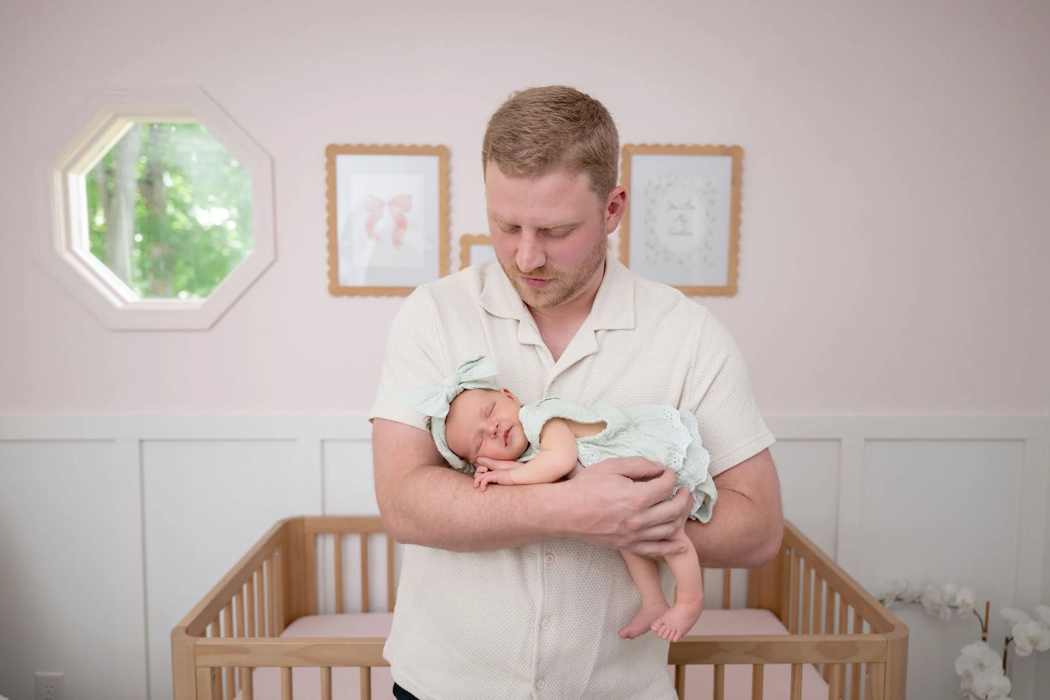 Dad holding baby in his arms and looking at baby
