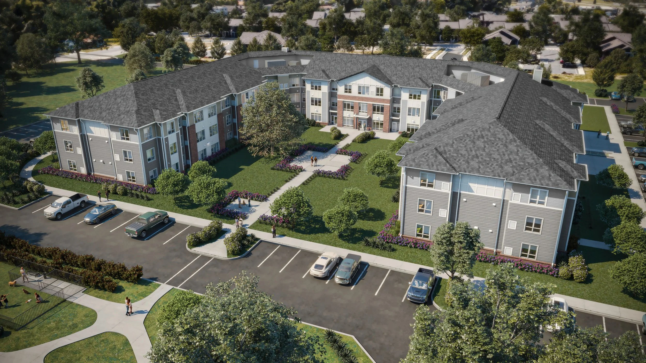 Aerial view of a residential apartment complex with green lawns, trees, pathways, parking lot, and surrounding neighborhood.