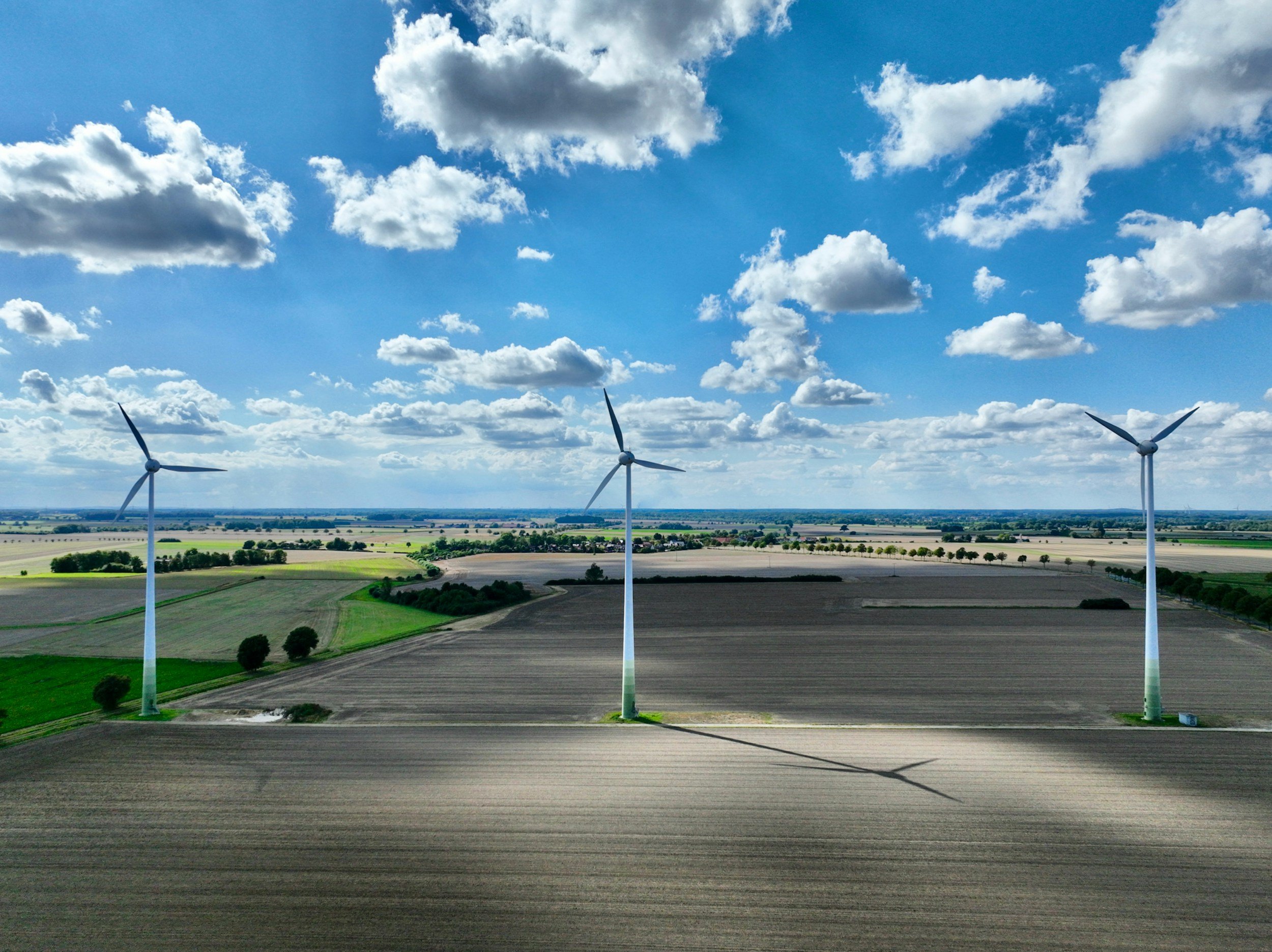 Three turbines in an agricultural field.