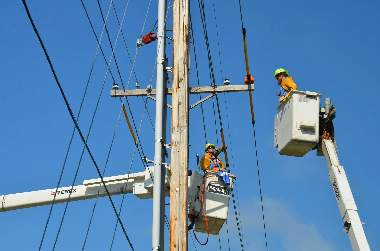 Utility workers near electricity lines.