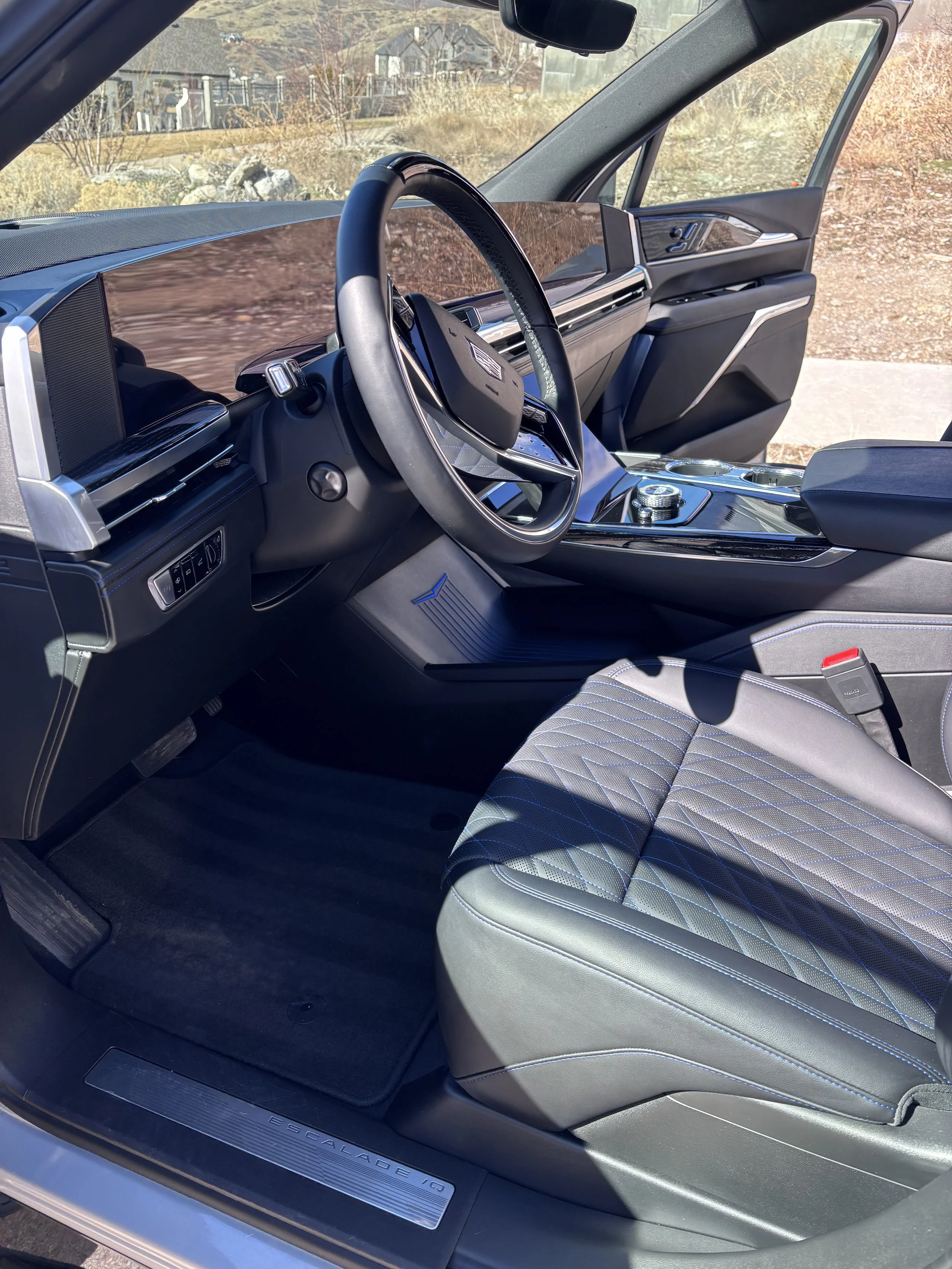 Interior view of a futuristic car showing the driver's seat, steering wheel, dashboard, and center console.