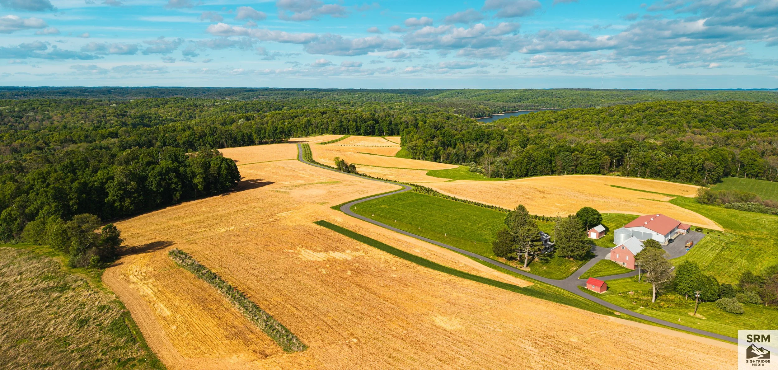 Homestead: A homestead and its barns at the end of a winding lane, surrounded by open fields. Northern Maryland.