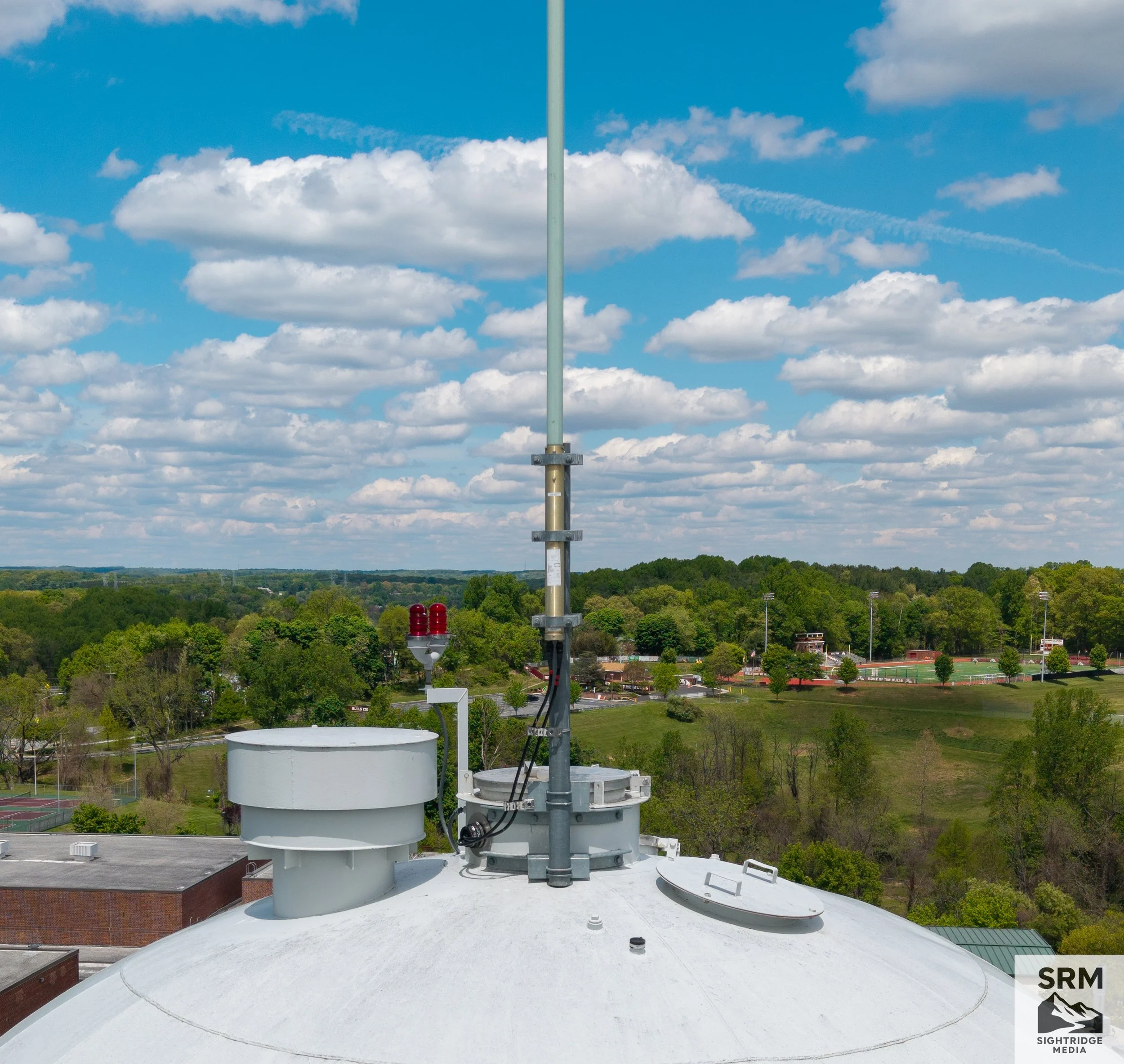 Water Tower Equipment Documentation — Close-up aerial detail of antenna arrays and communication equipment mounted to water tower structure — no climb team required.