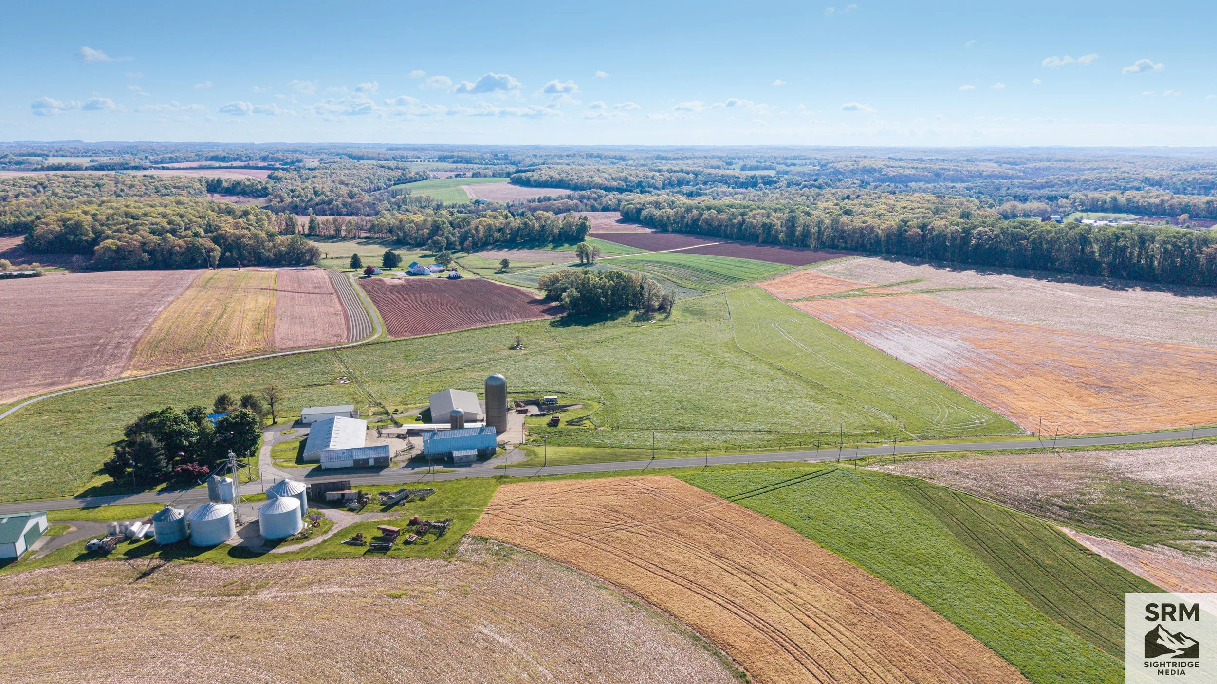 Farm Aerial Overview — Buildings, grain silos, and surrounding fields documented from above showing full farm operation — Northern Maryland.