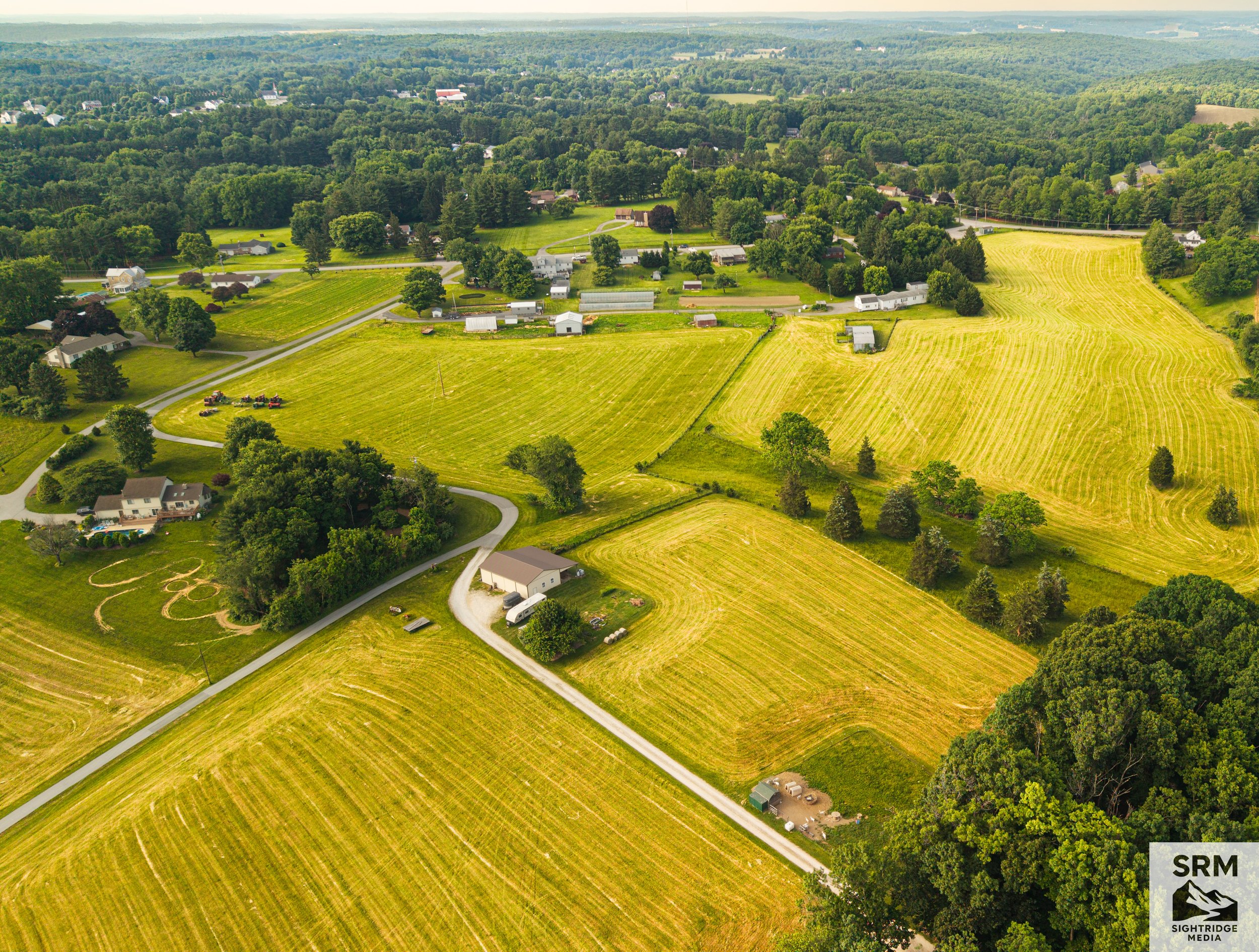 Early summer over the Hereford Zone — a patchwork of cut fields, farm lanes, and tree lines from above.