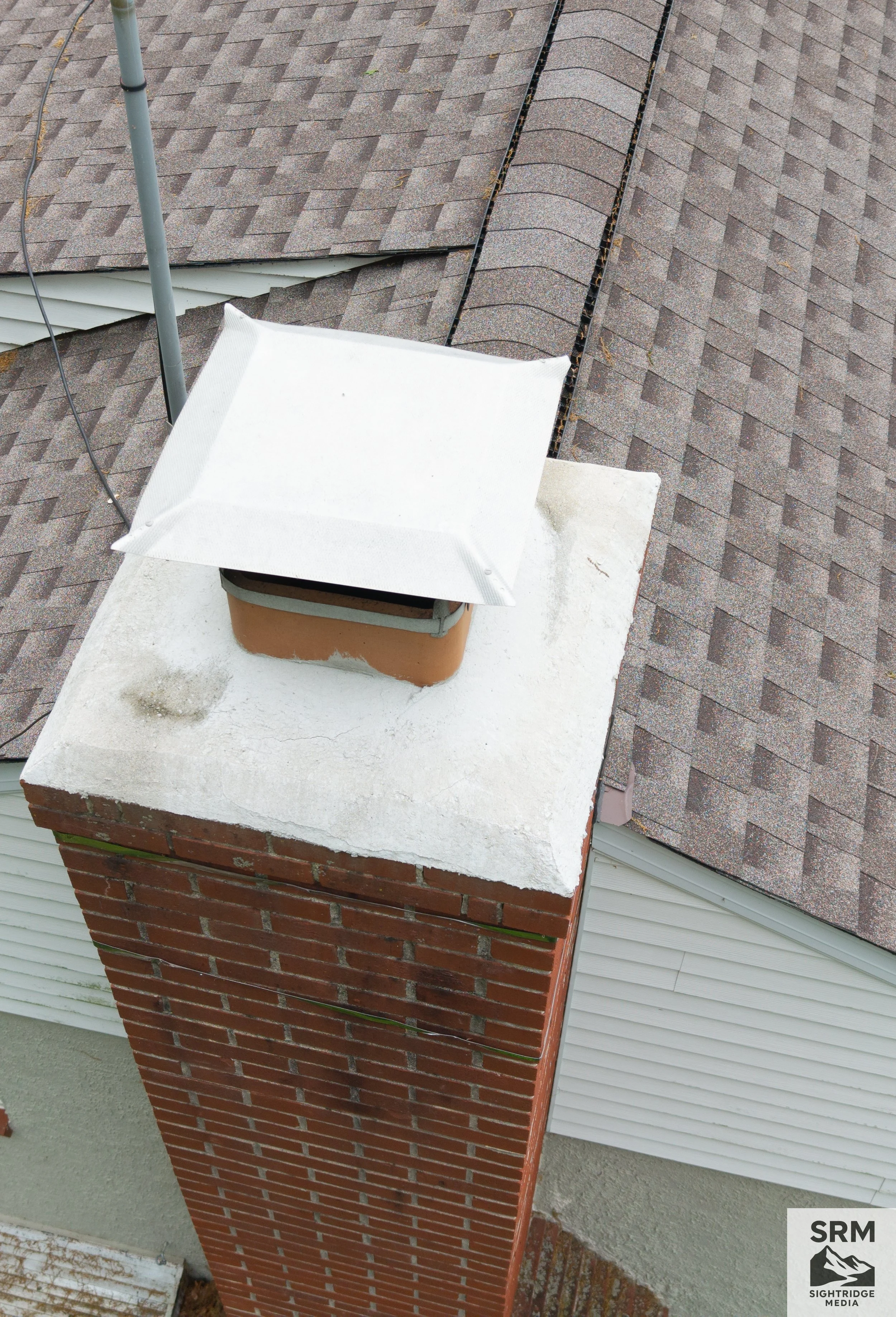 Chimney Crown Detail - Aerial close-up of chimney crown showing mortar condition, cracking, and weathering — critical inspection point for water intrusion.