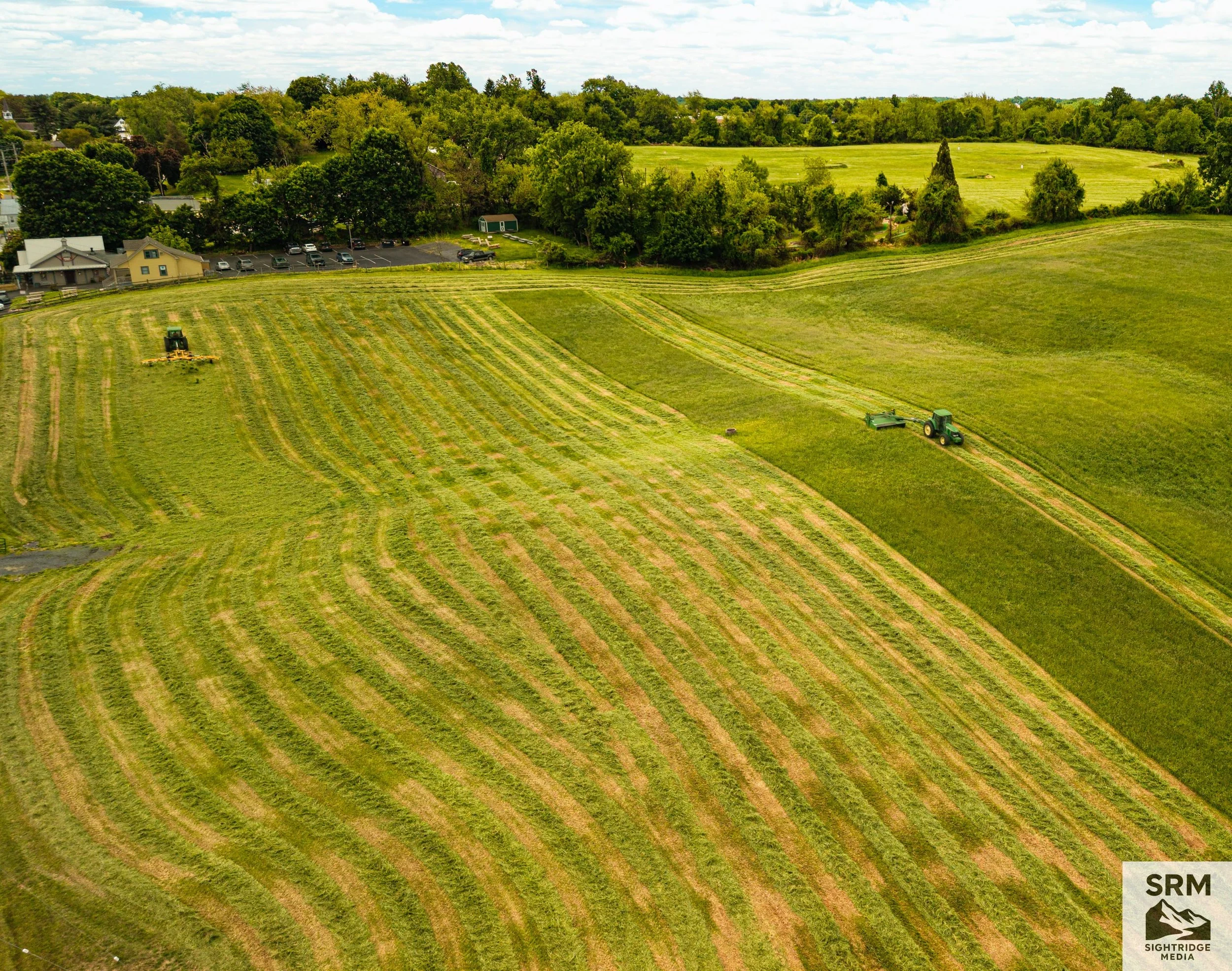 Agricultural Hay Harvest — Aerial overview of first-cut hay season showing mowing patterns, field contours, and active harvesting operations — Hereford, Maryland.