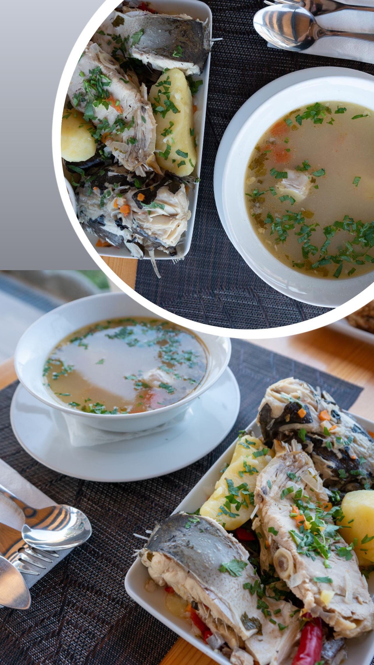 Two plates of fish with potatoes and vegetables, and two bowls of clear soup garnished with herbs on a dining table.