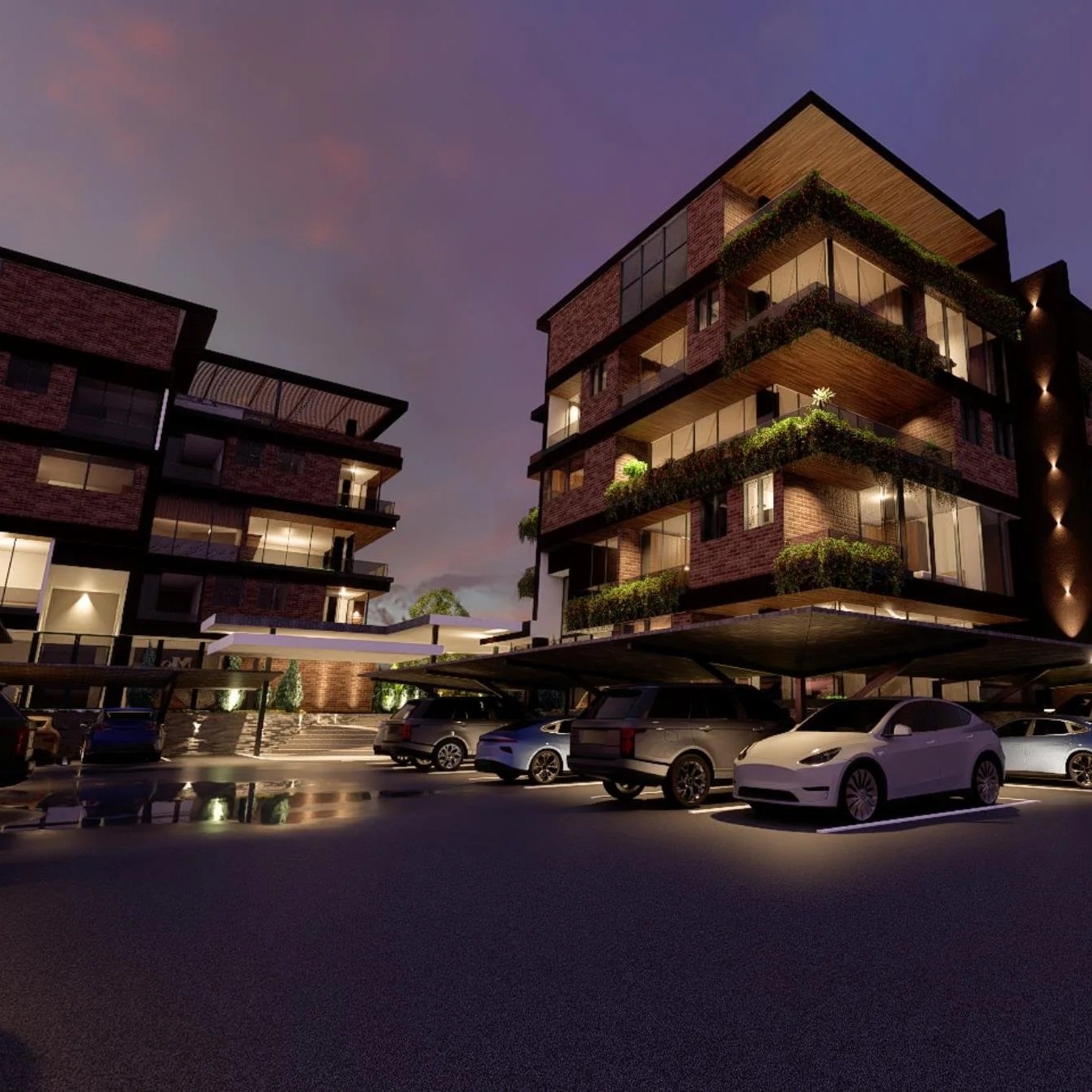 Nighttime view of modern residential buildings with large glass windows and balconies, parking lot with several cars, and a dark sky with a hint of sunset colors.