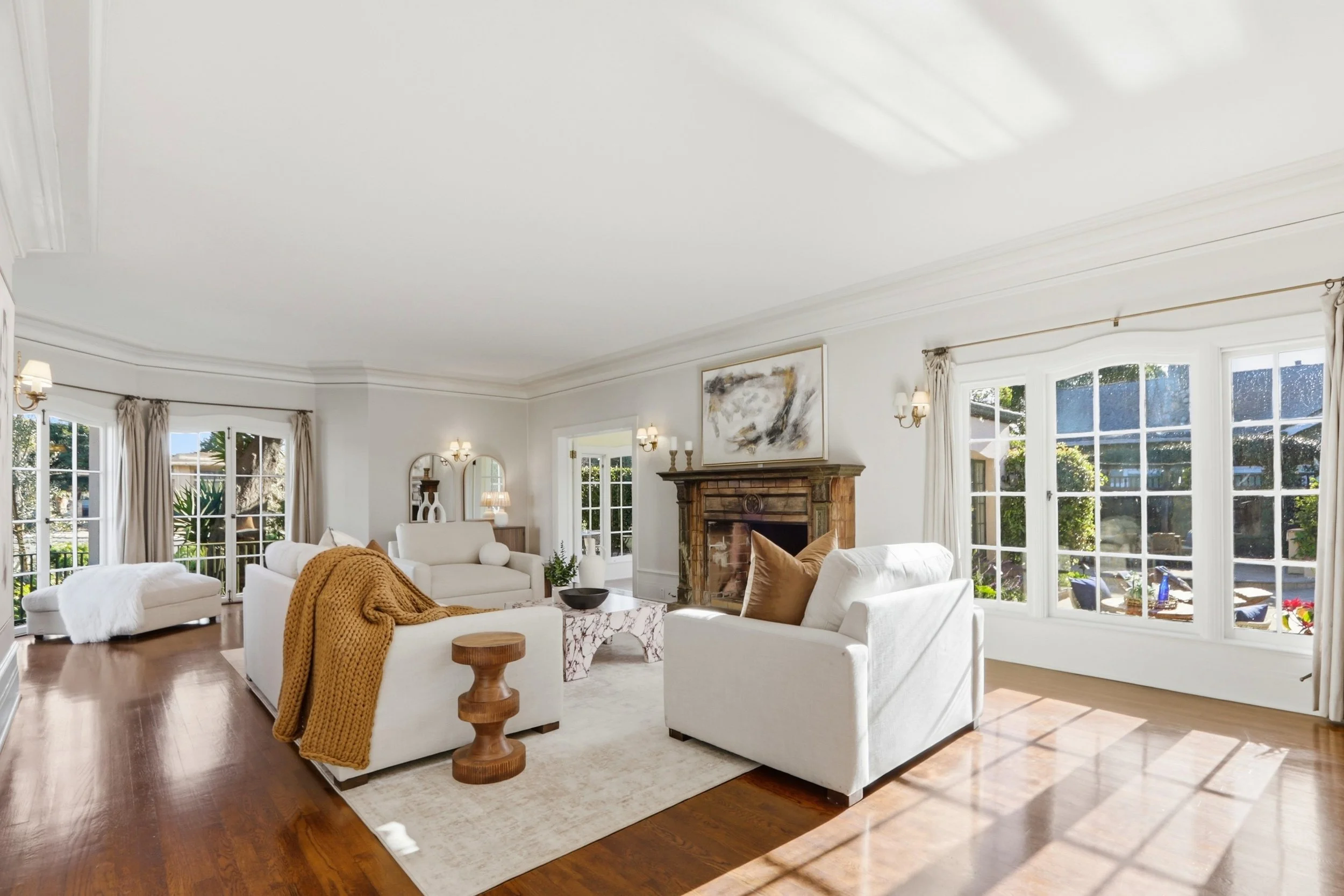 Grand formal living room features an inviting Batchelder tile fireplace.