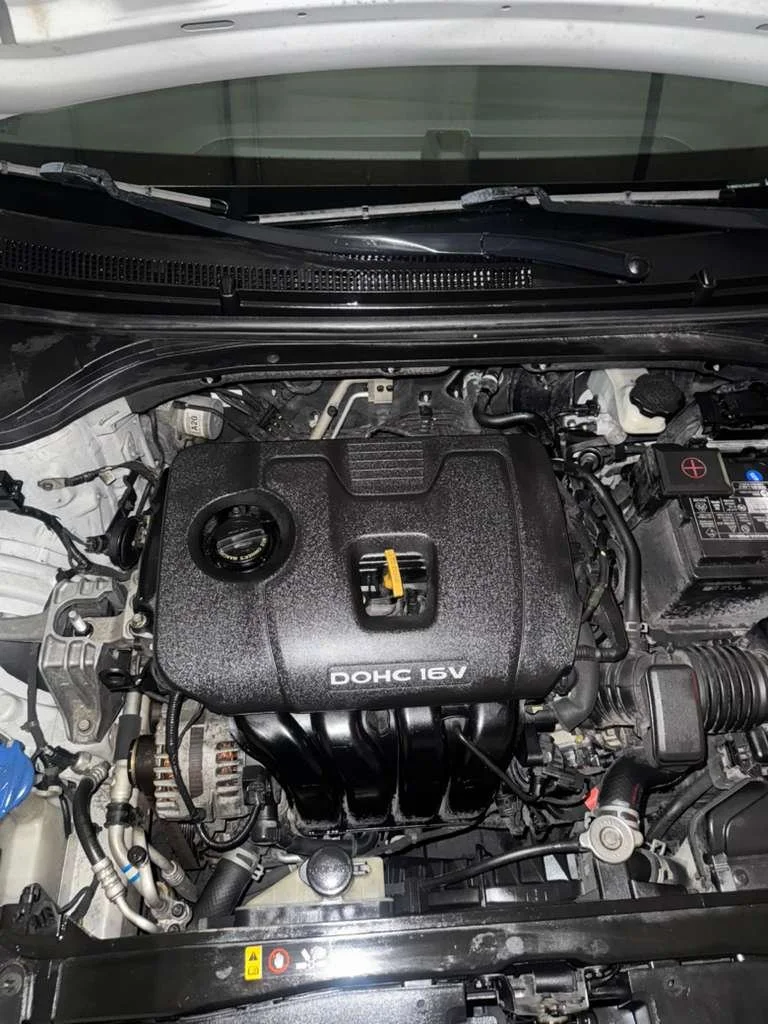 Car engine bay with a DOHC 16V engine, various visible components, and a windshield at the top of the image.
