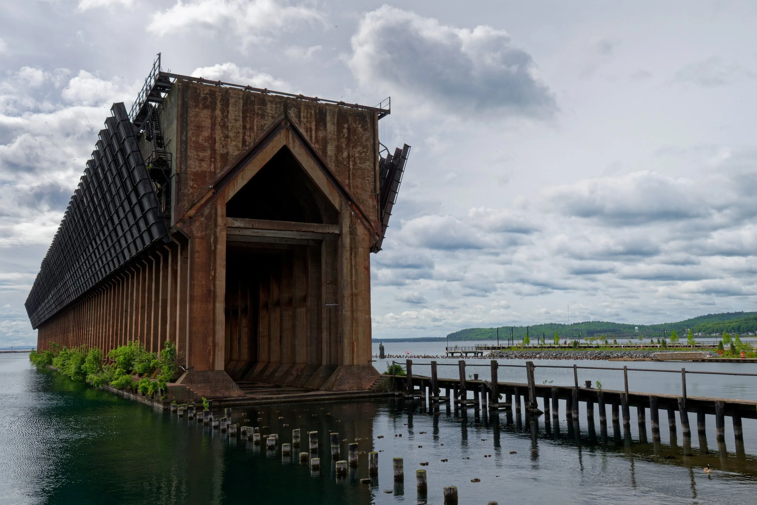 An old, abandoned building partially submerged in water with a cloudy sky overhead.