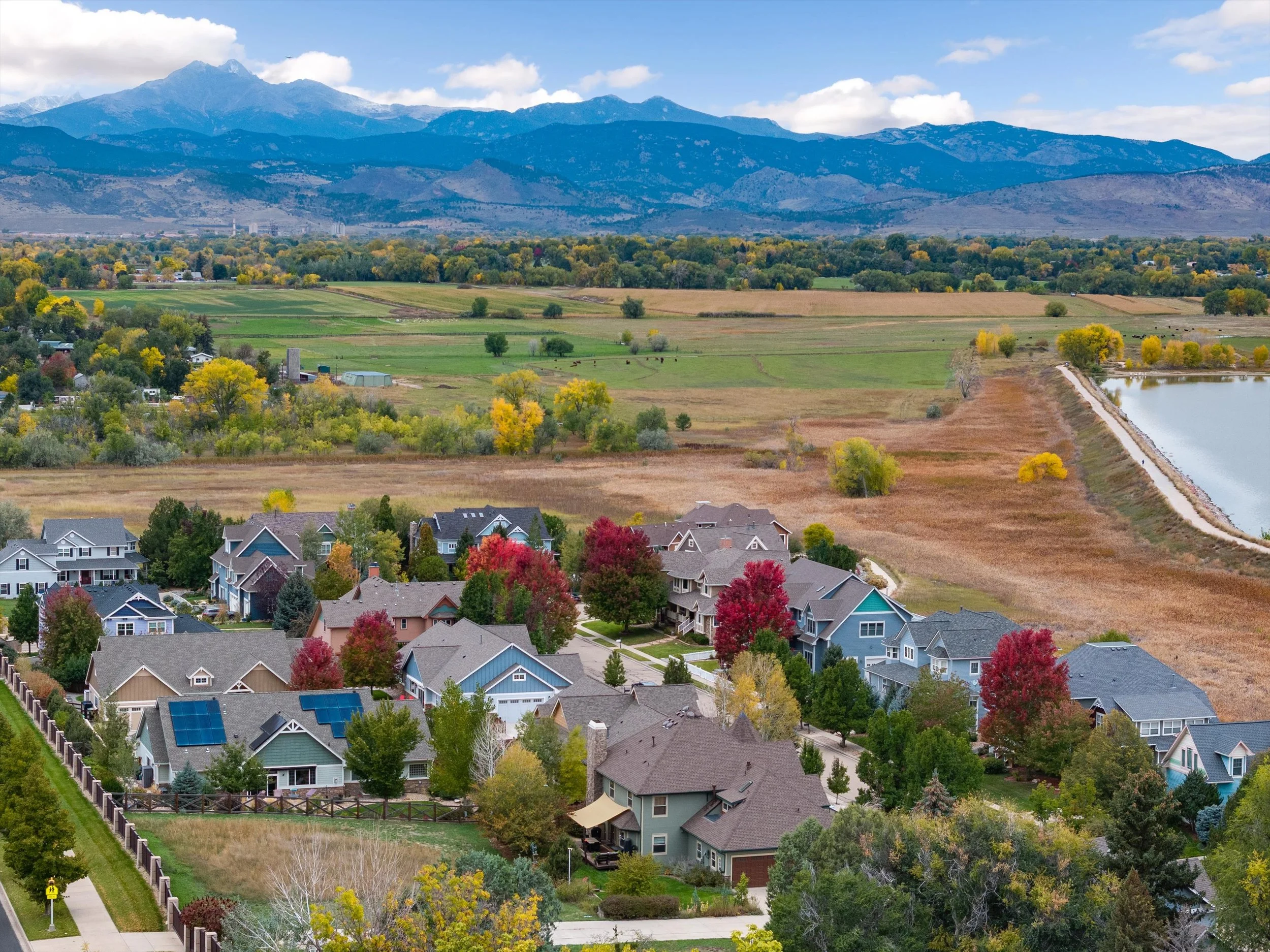 A neighborhood with houses surrounded by trees with autumn foliage near Lake McIntosh with an expansive rural landscape and mountains in the background. Located minutes to highly rates schools and amenities. 