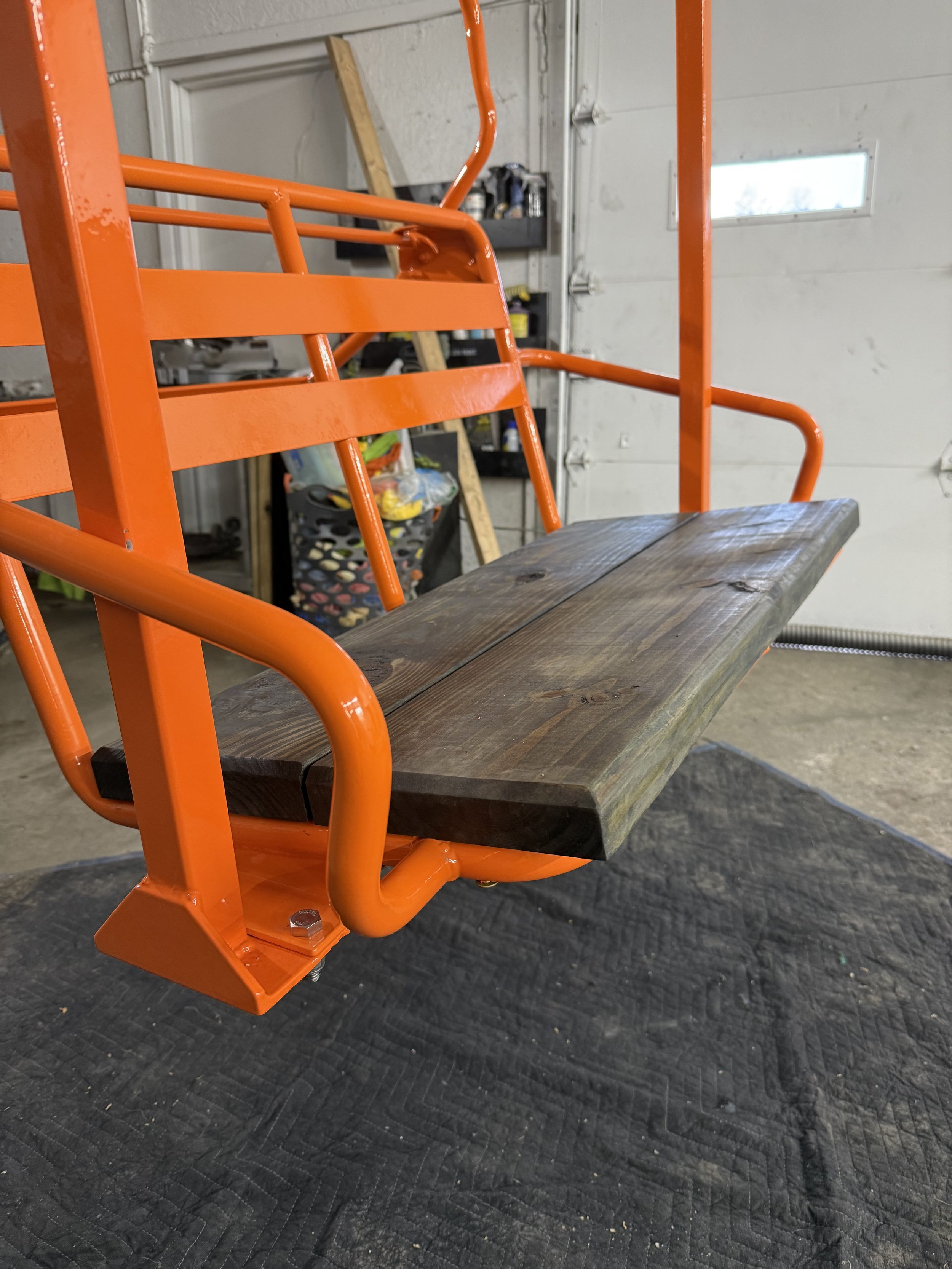 Orange metal hand truck with wooden platform in a garage