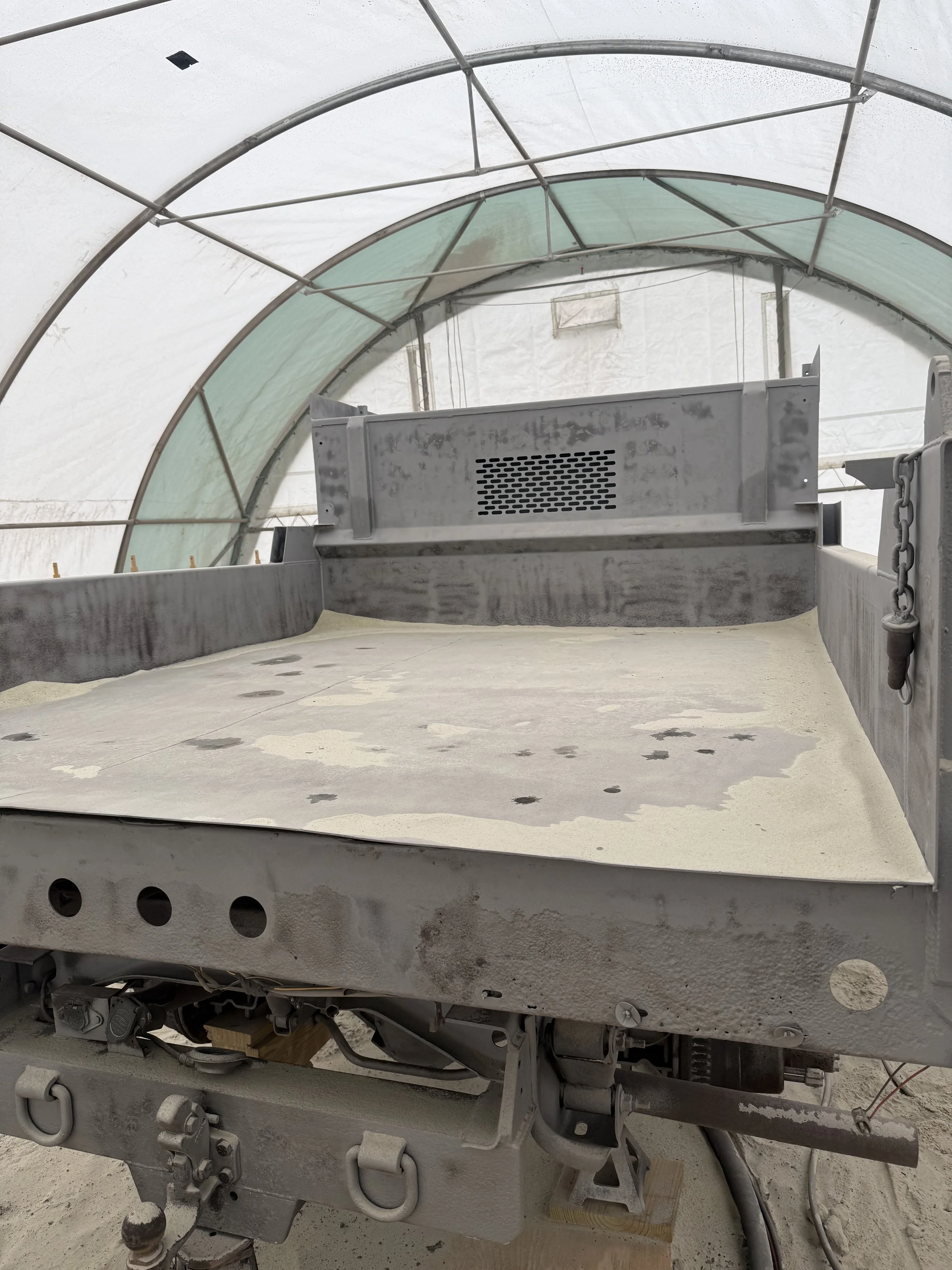 A large industrial machine or robotic equipment inside a greenhouse-like enclosure.