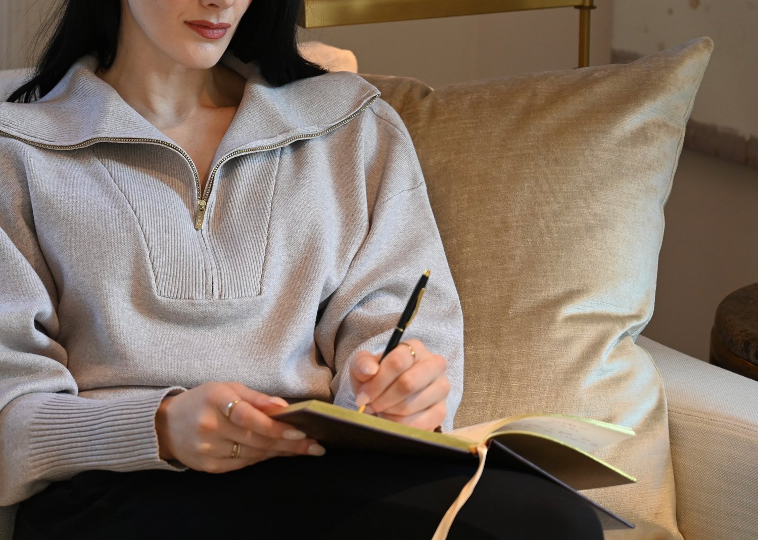 What actually changes when you hire an wellness advisor woman sitting on couch writing in journal, reflecting