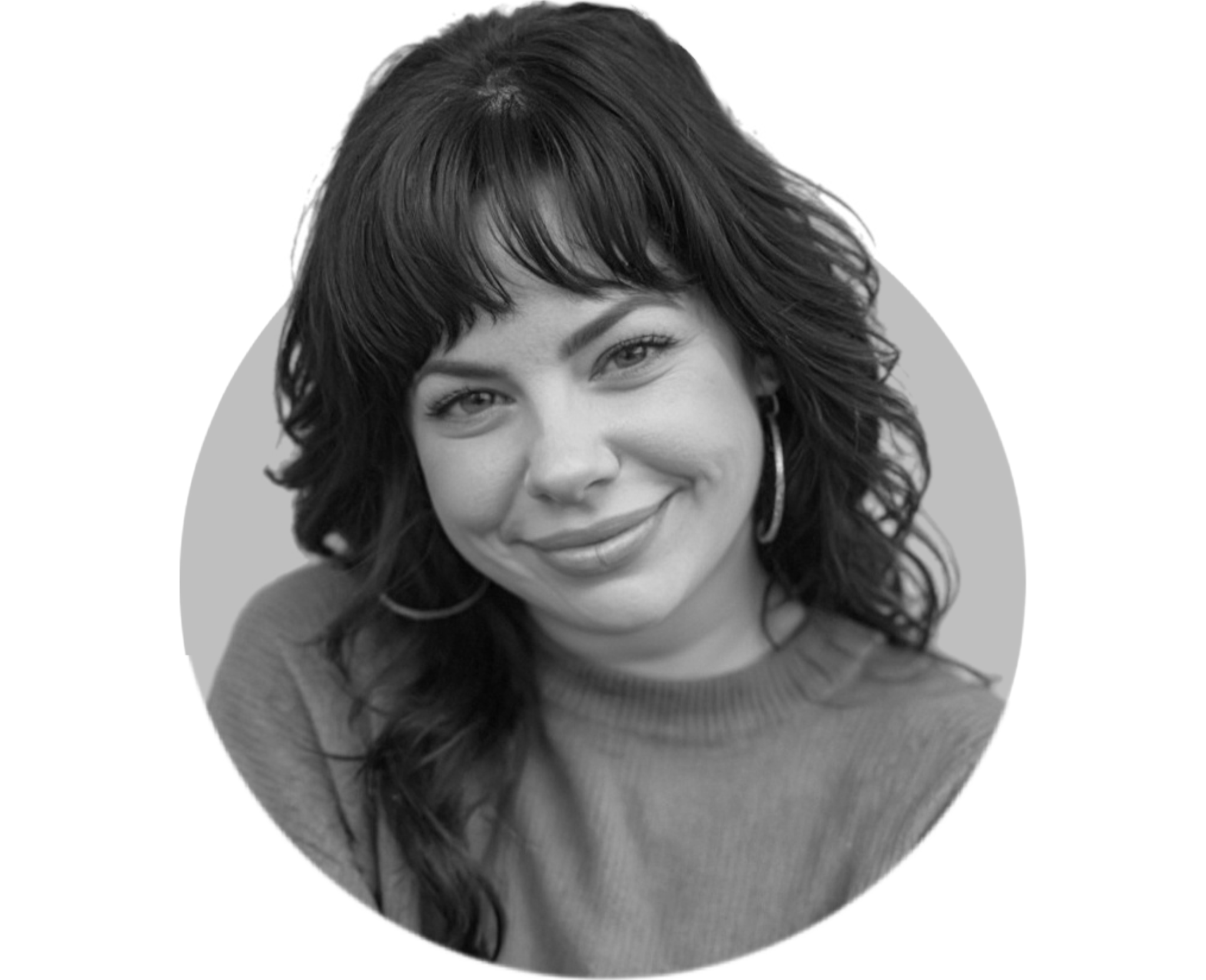 Black and white portrait of a woman with short, curly hair smiling, wearing a top and earrings.