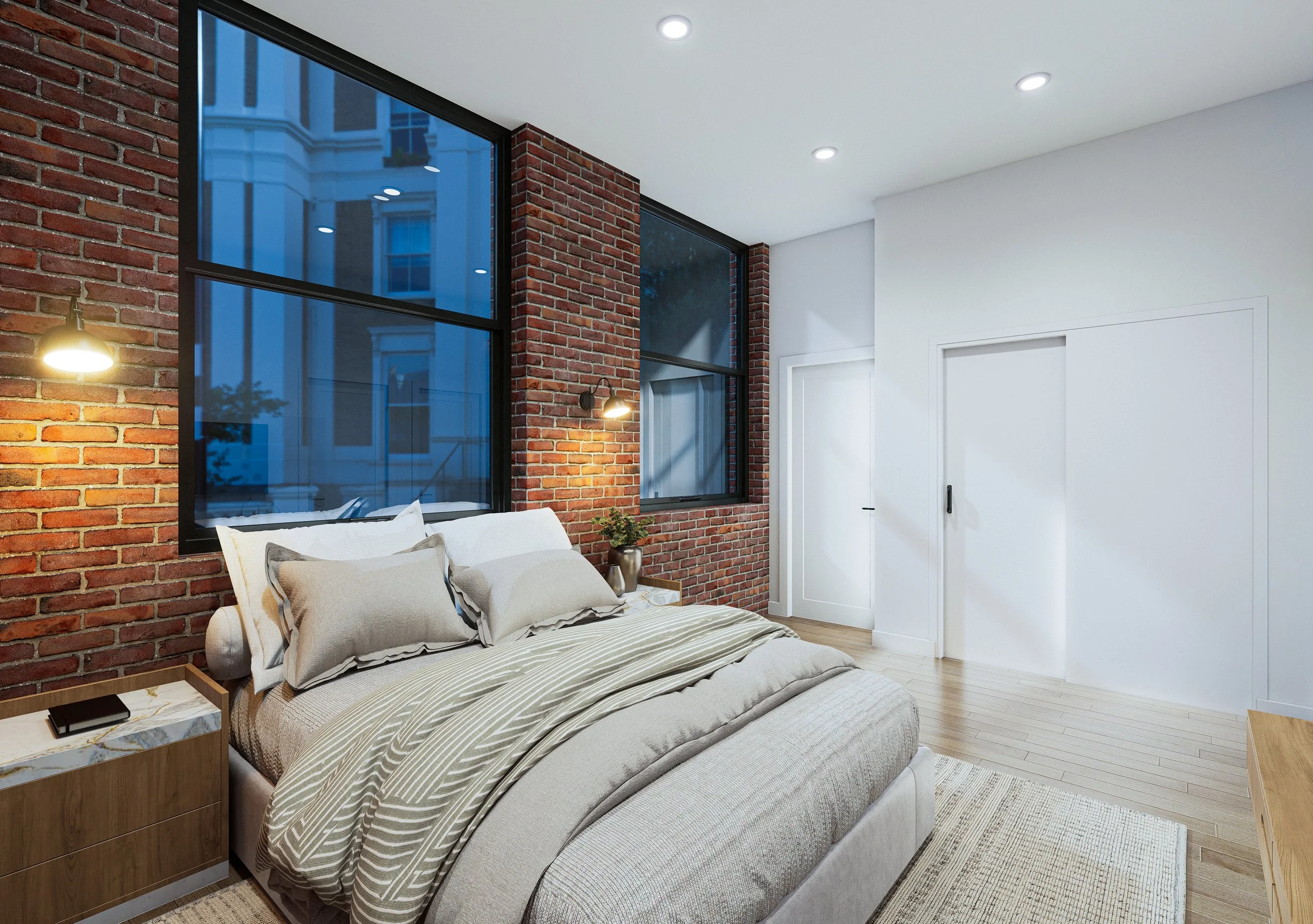 Modern bedroom with brick accent wall, large windows, white ceiling with recessed lighting, and a bed with beige and patterned bedding. There is a nightstand with a book and TV remote, a small potted plant, and a white door.