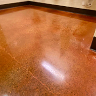 Close-up of a polished, reddish-brown terrazzo floor with some reflections.