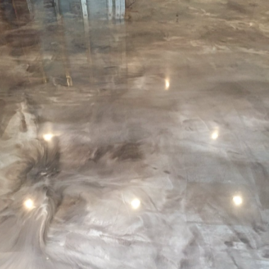 Shiny, polished concrete floor with reflections of lights.