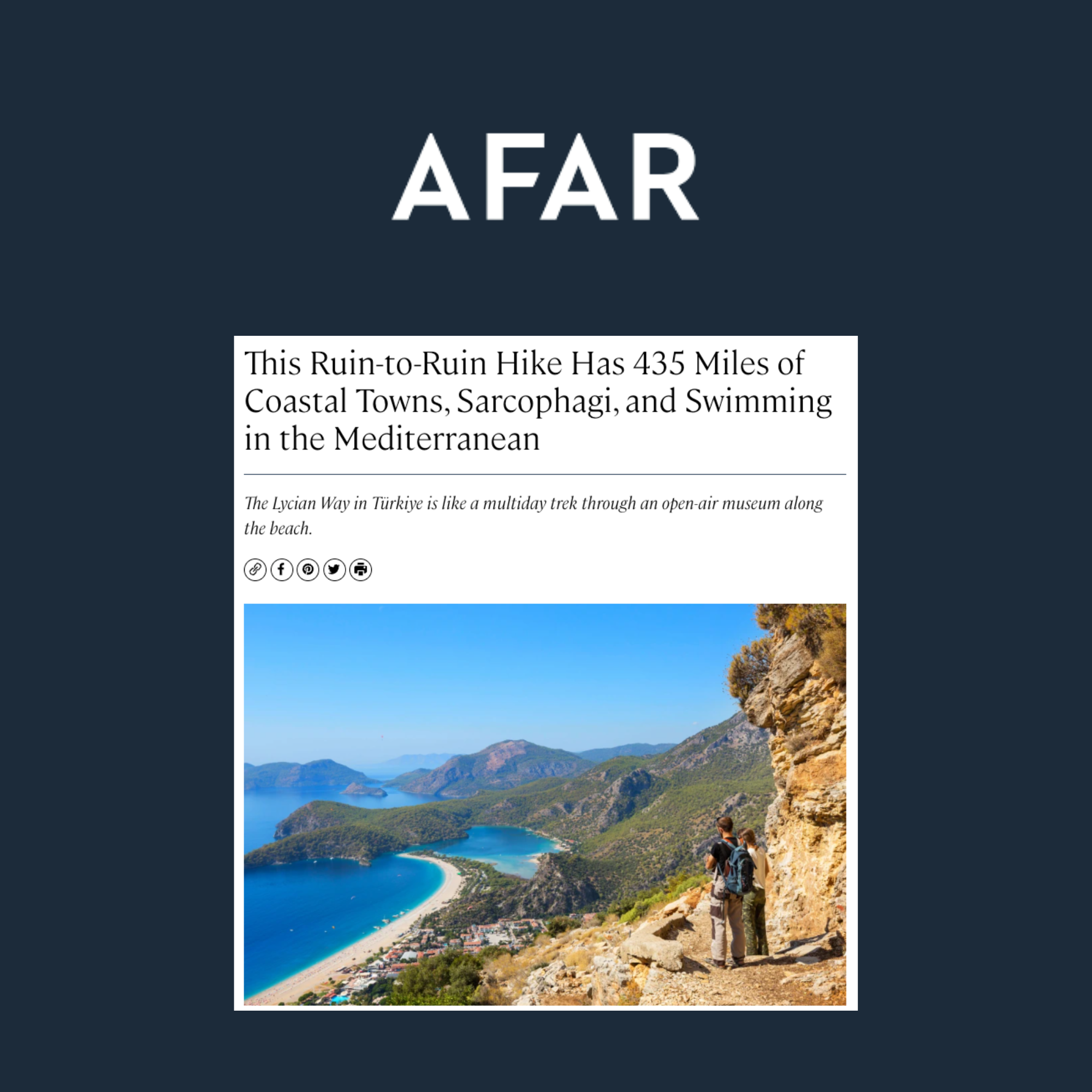 Hikers walking along a mountain trail overlooking a coastal town and Mediterranean Sea with mountains in the distance.