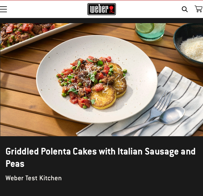 Griddled polenta cakes with italian sausage and peas on a white plate.  Plate is sitting on top of a brown picnic table with a cold drink, parmesan cheese in a bowl and forks and knives on a napkin.