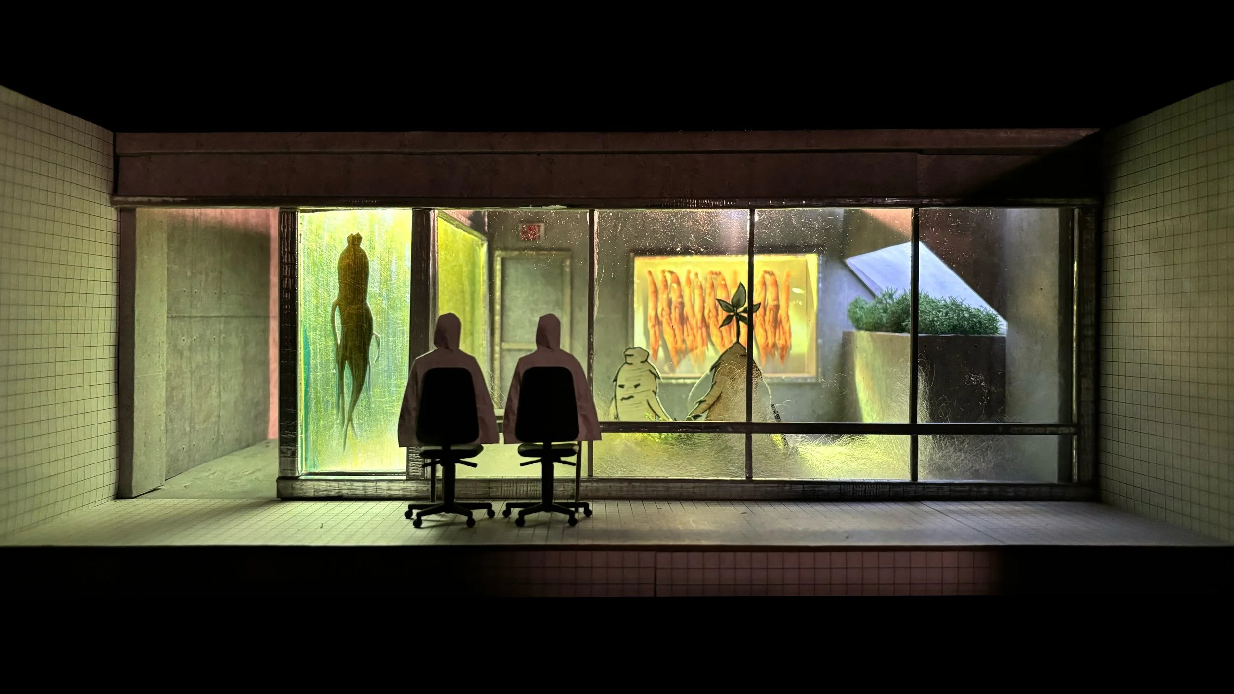 View through a large glass window showing two office chairs facing a mural of a green squirrel, a stack of orange carrots, and a green plant on a yellow background.