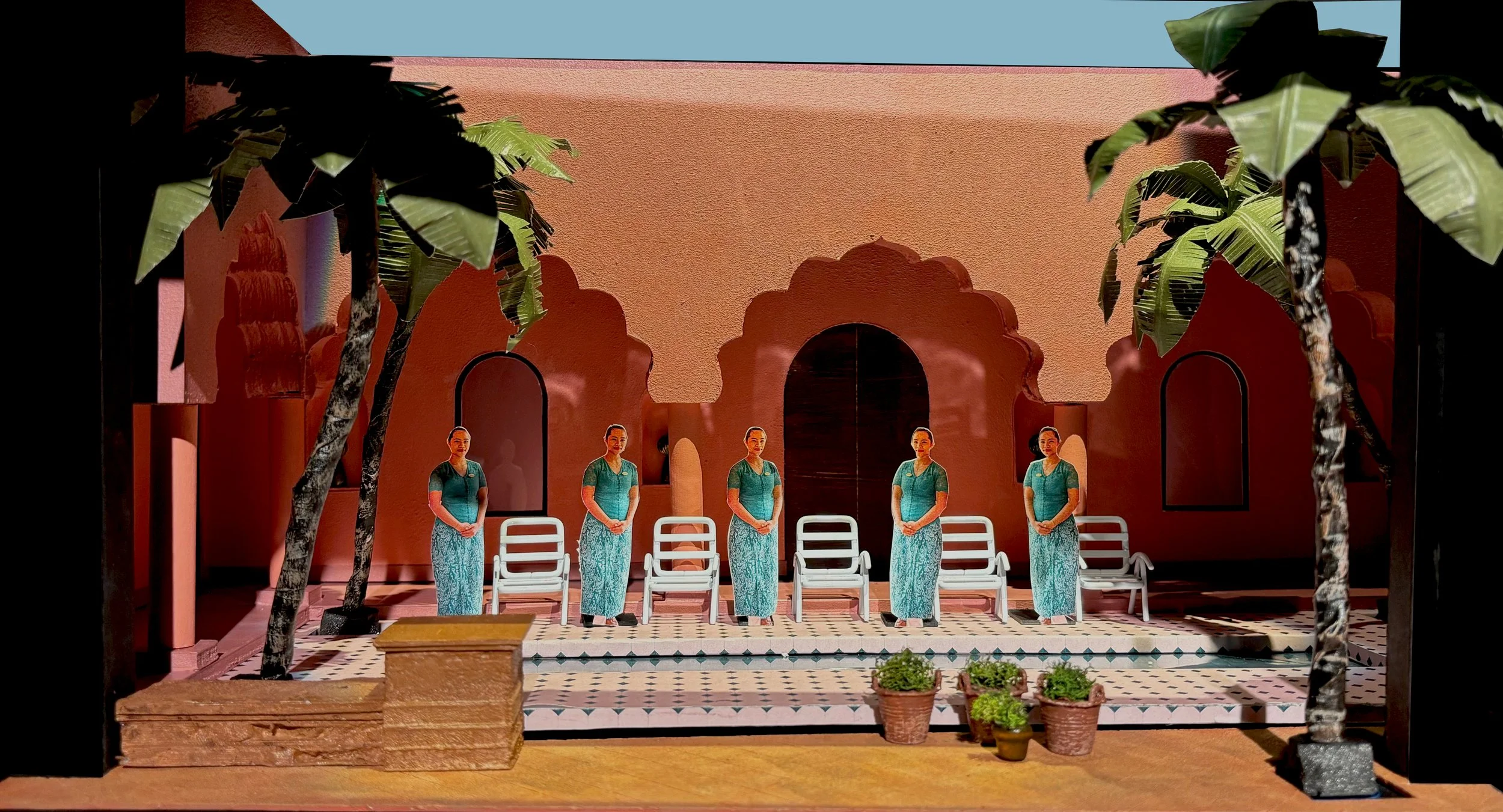 Miniature scene of five women standing in front of a peach-colored wall with arched windows, surrounded by potted plants and two small trees, with chairs and a bench nearby.