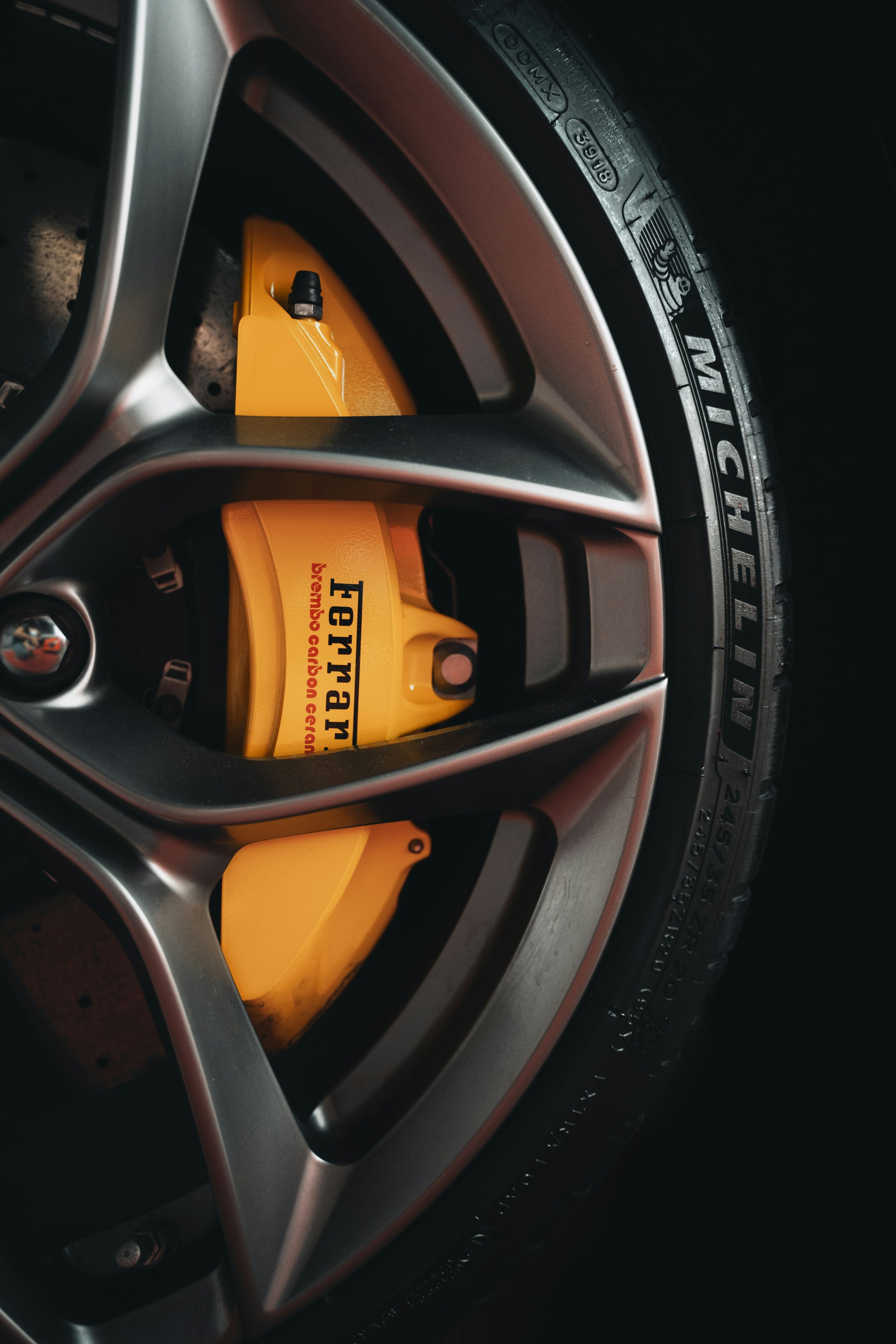 Close-up of a Ferrari wheel with a yellow brake caliper with Ferrari written on it