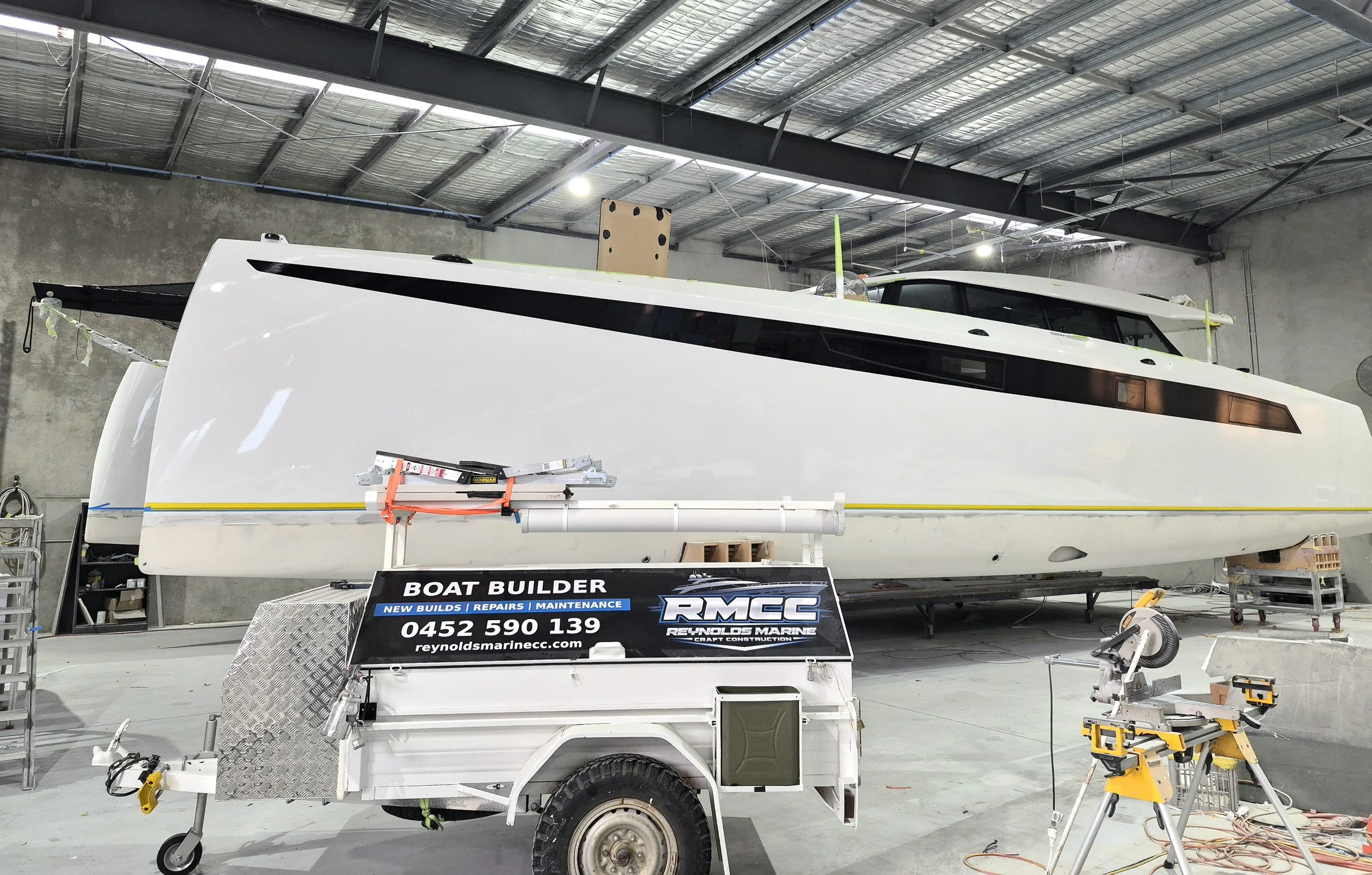 Catamaran under construction in the RMCC workshop with the service vehicle in front.