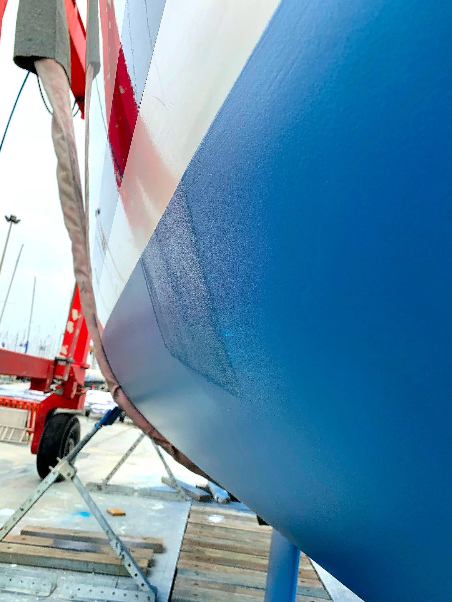 Fresh blue antifouling along a yacht hull.
