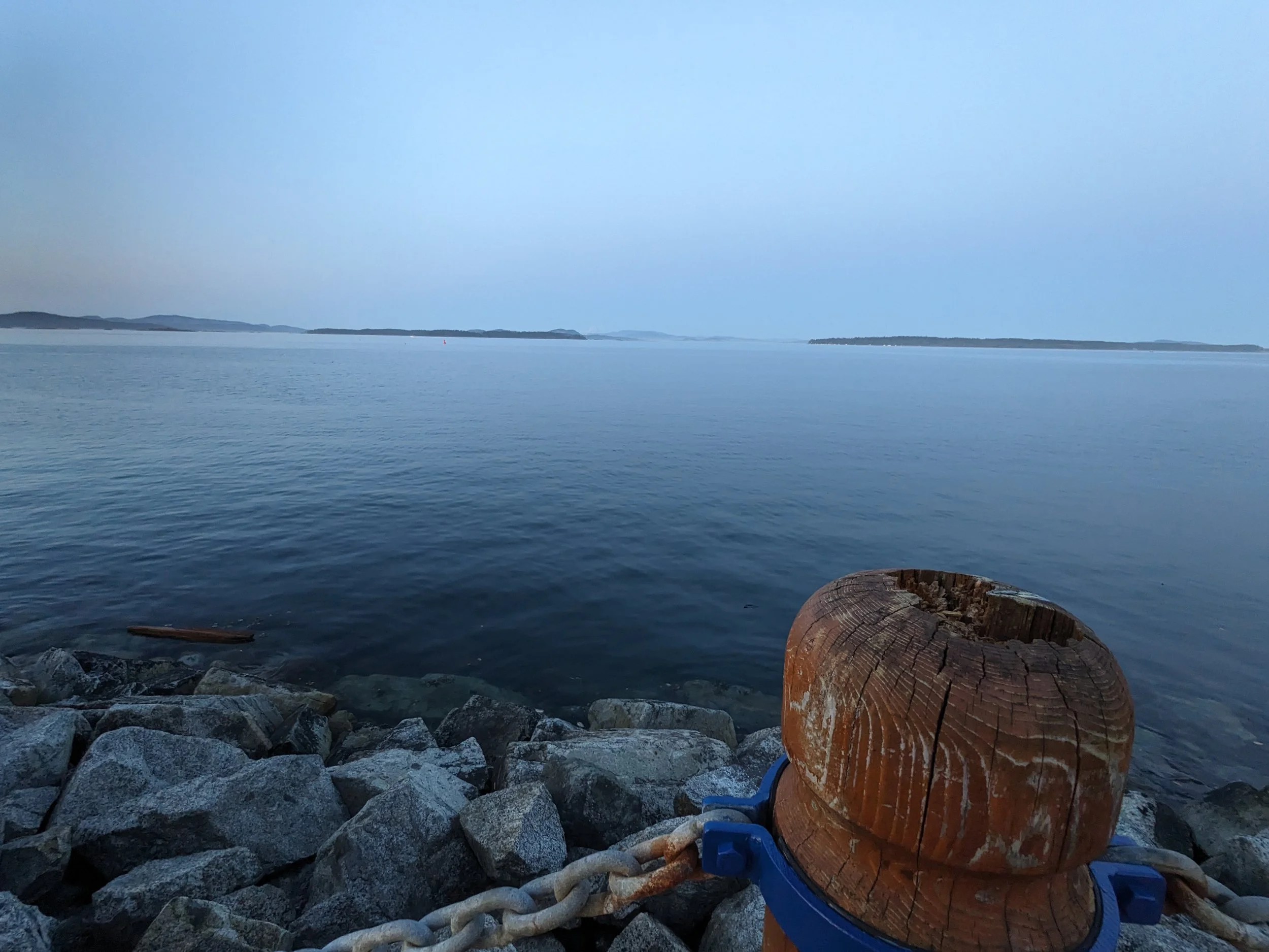 The ocean, a rocky beach and a large wooden boat tether.
