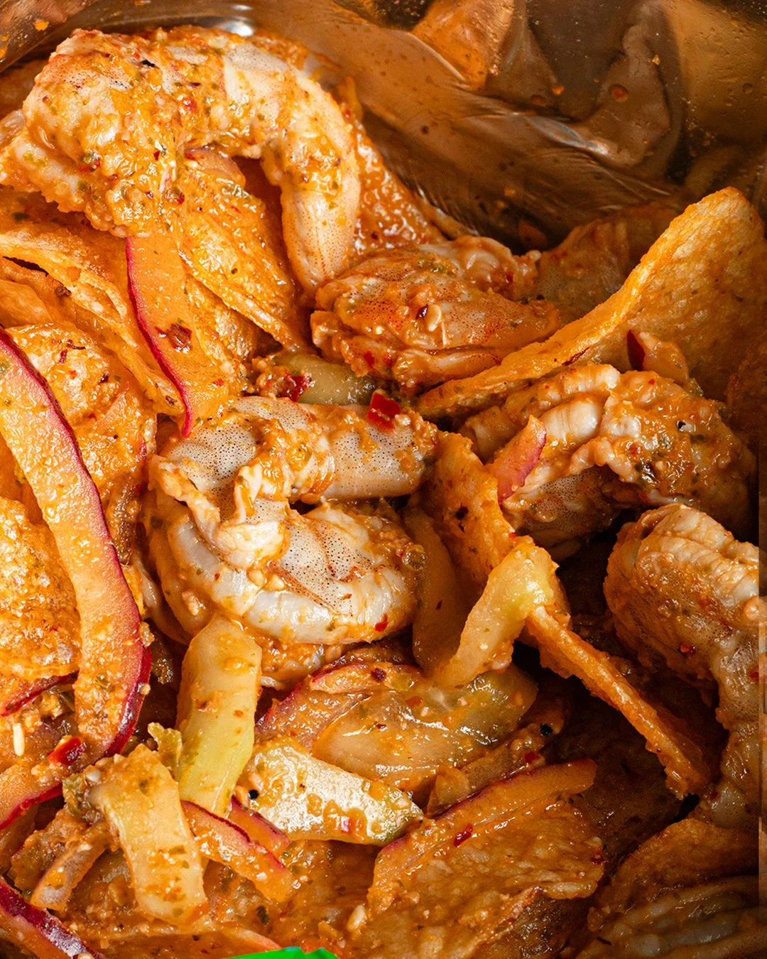 Close-up of a cooked seafood and vegetable dish with shrimp, scallops, vegetables, and sauce.