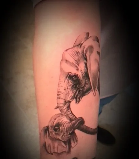Tatouage d'une éléphant et d'un éléphanteau en noir et blanc.