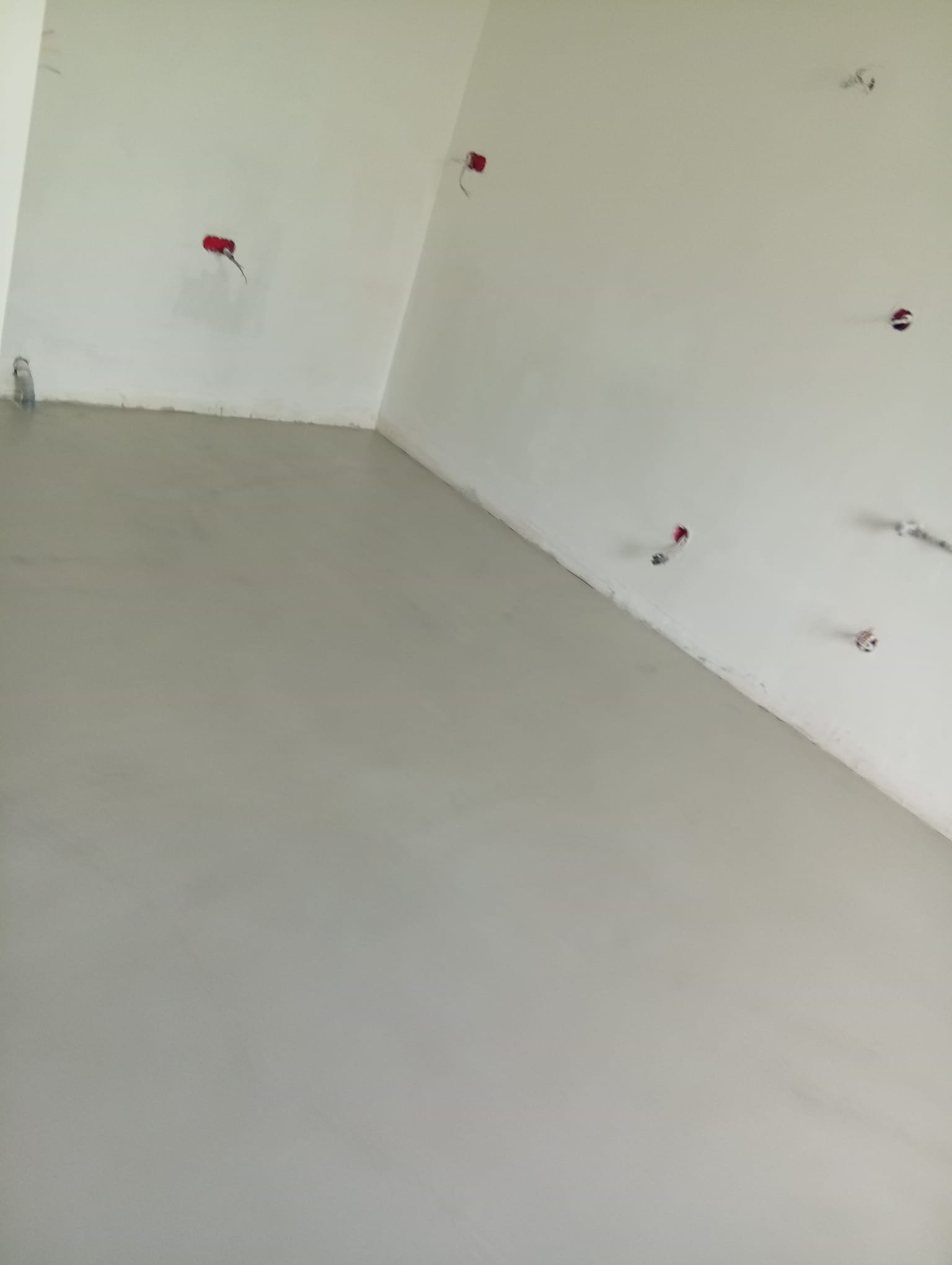 Mur en cours de construction avec plusieurs prises électriques encastrées dans le plafond.