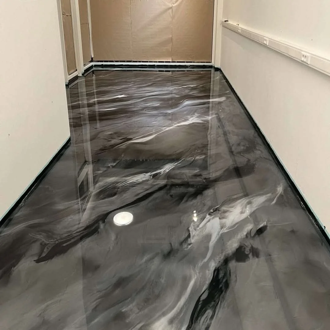 Sol en marbre noir avec veines blanches et grises dans un corridor en construction.