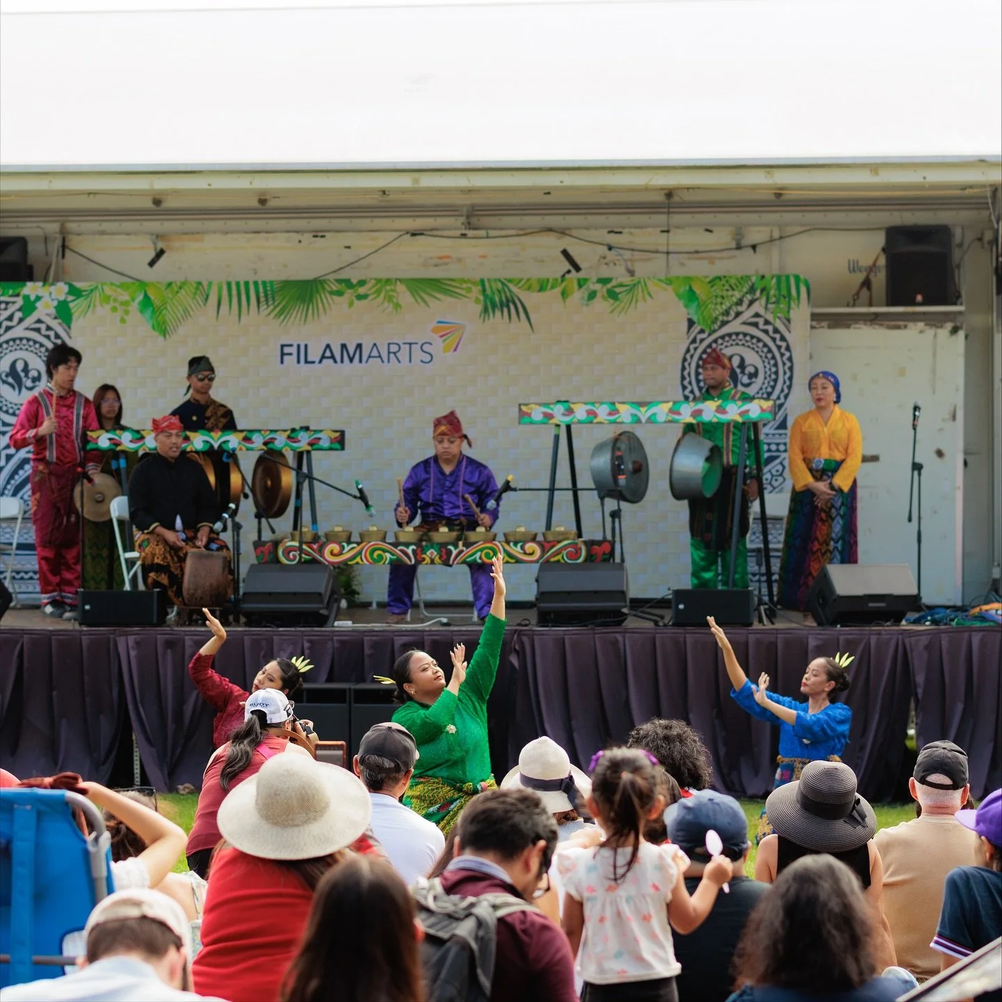 Band with gongs on stage with cultural dancers in front