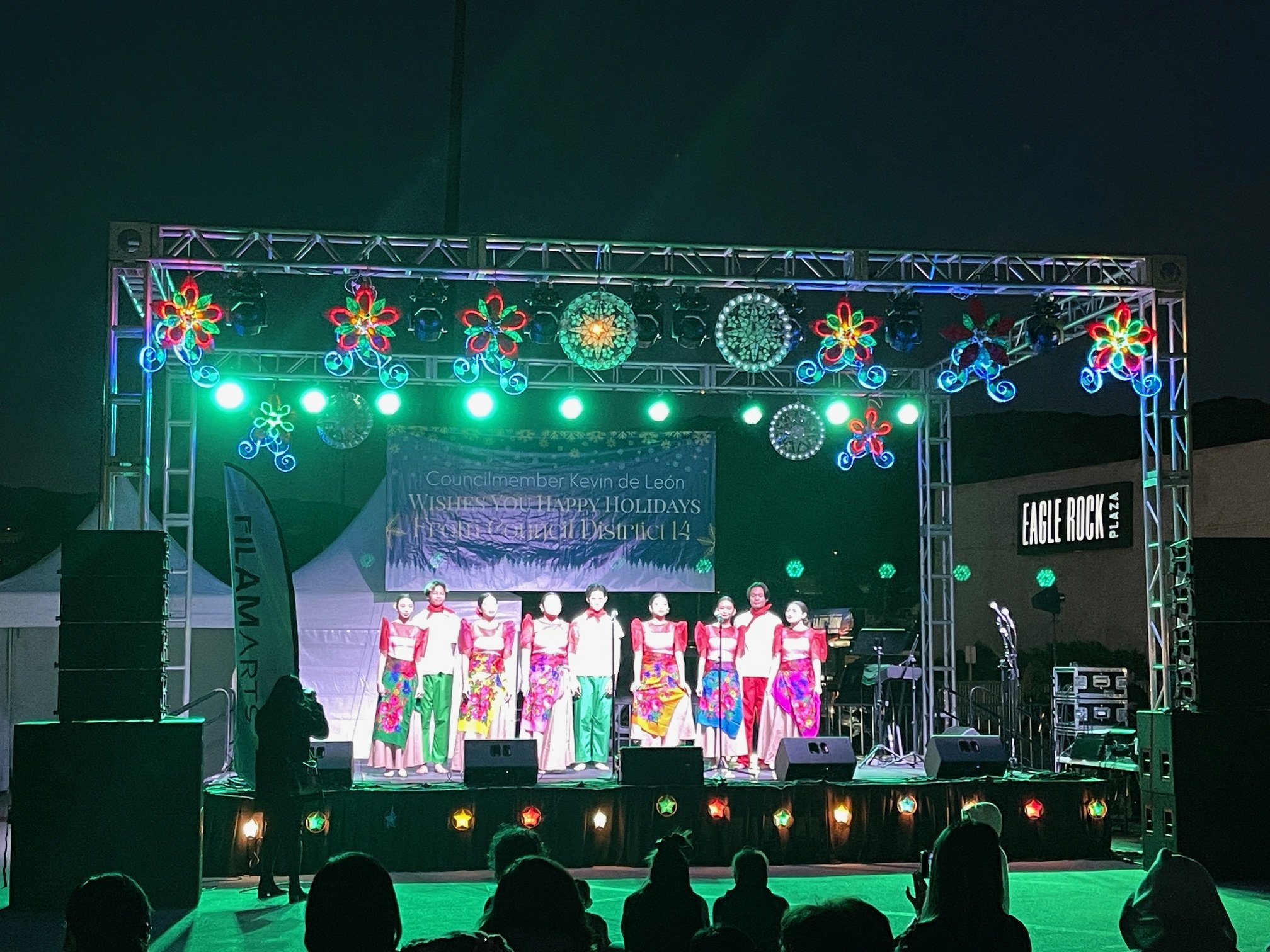 Filipino singers in costume on stage with parol lanterns