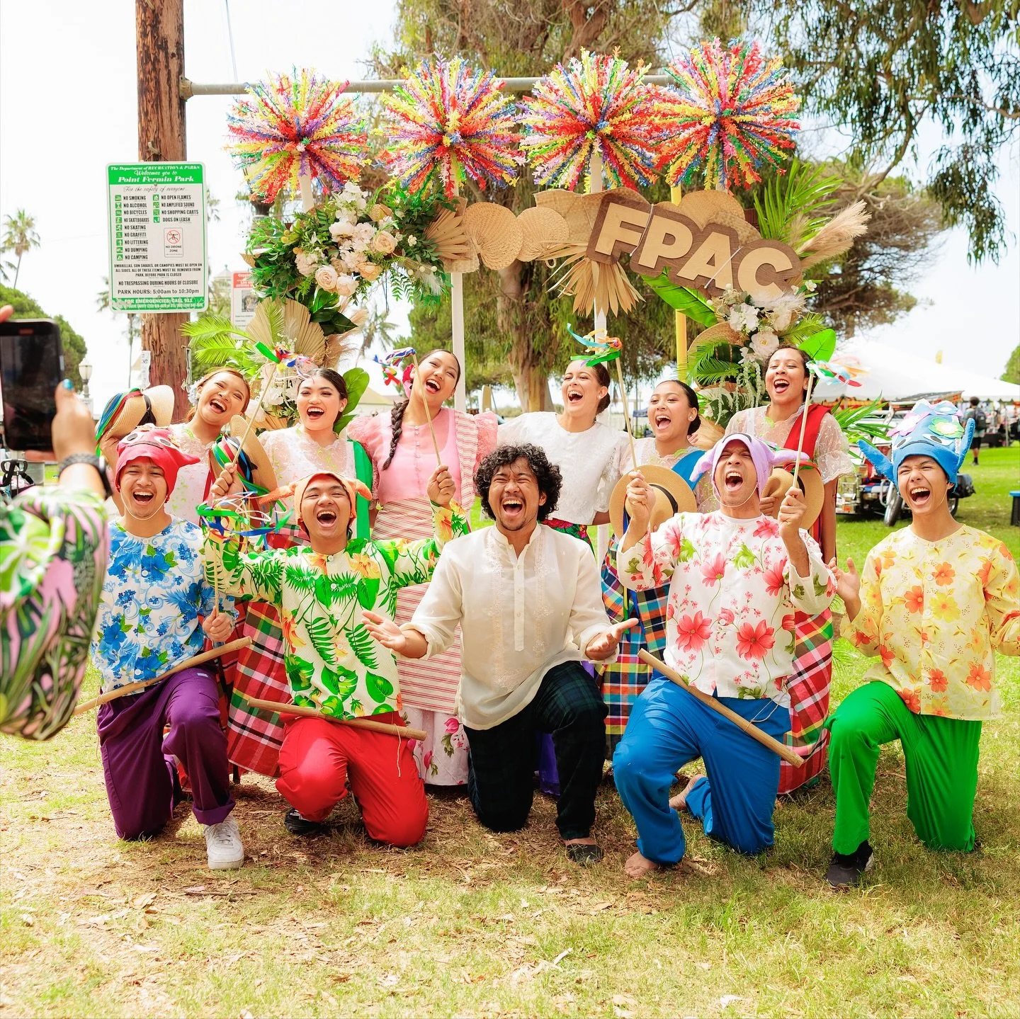 Dancers in Filipino costumes in front of FPAC arch