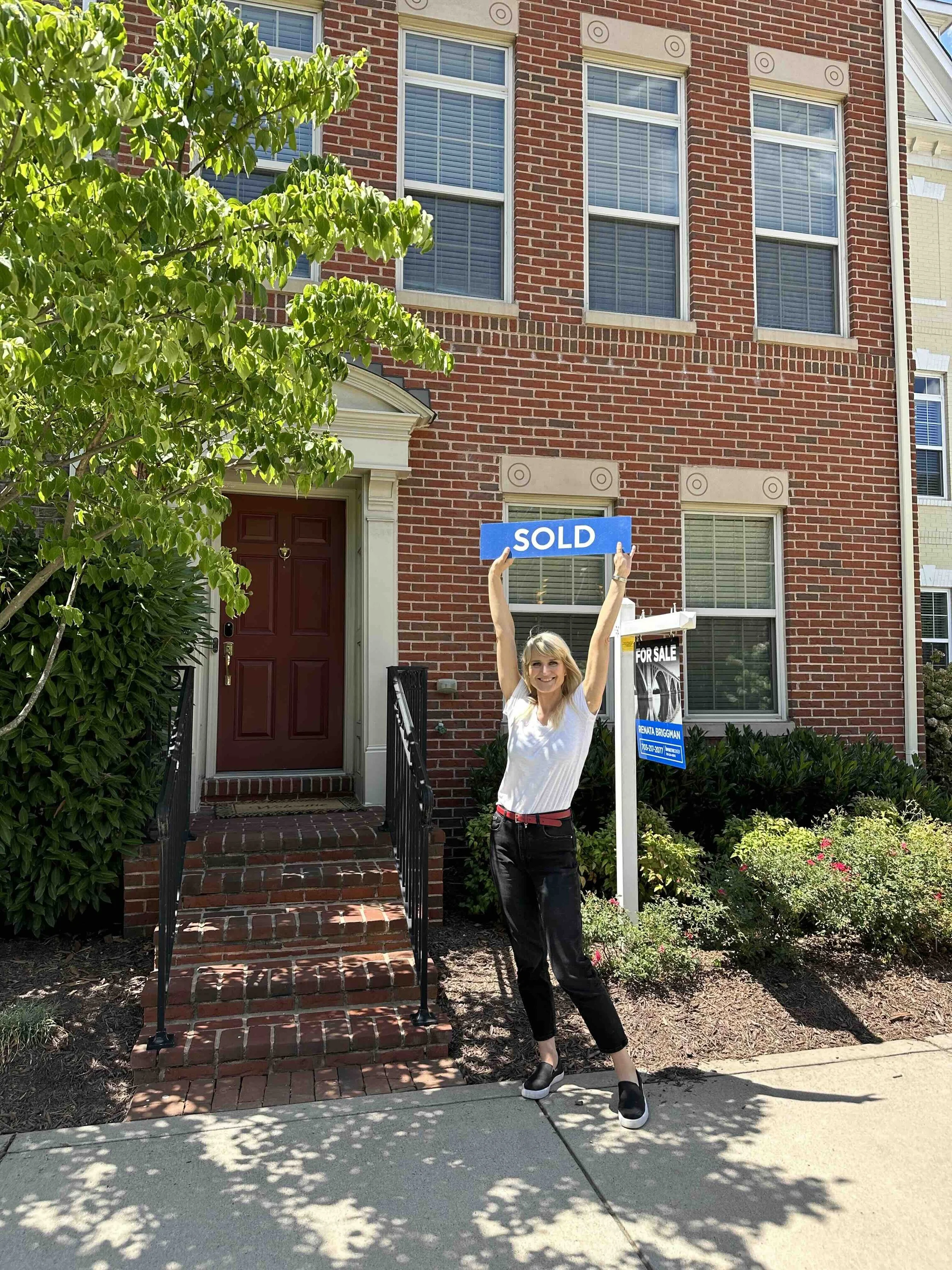 Renata Briggman with SOLD sign