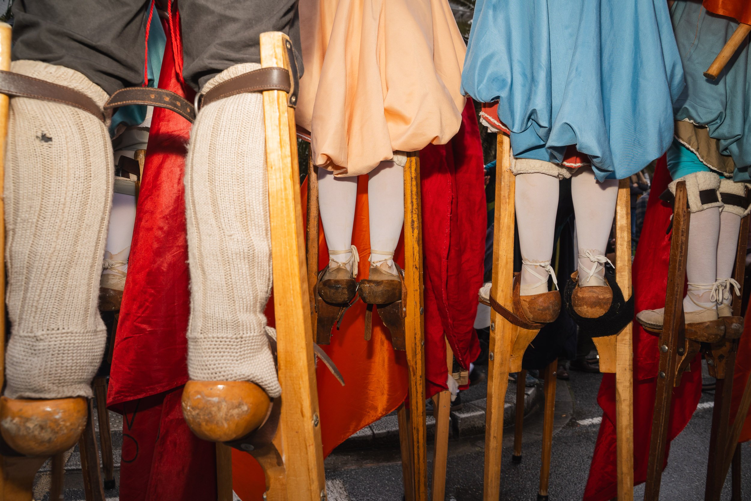 Traditional wooden dolls with snow shoes and colorful clothing displayed at an outdoor market.